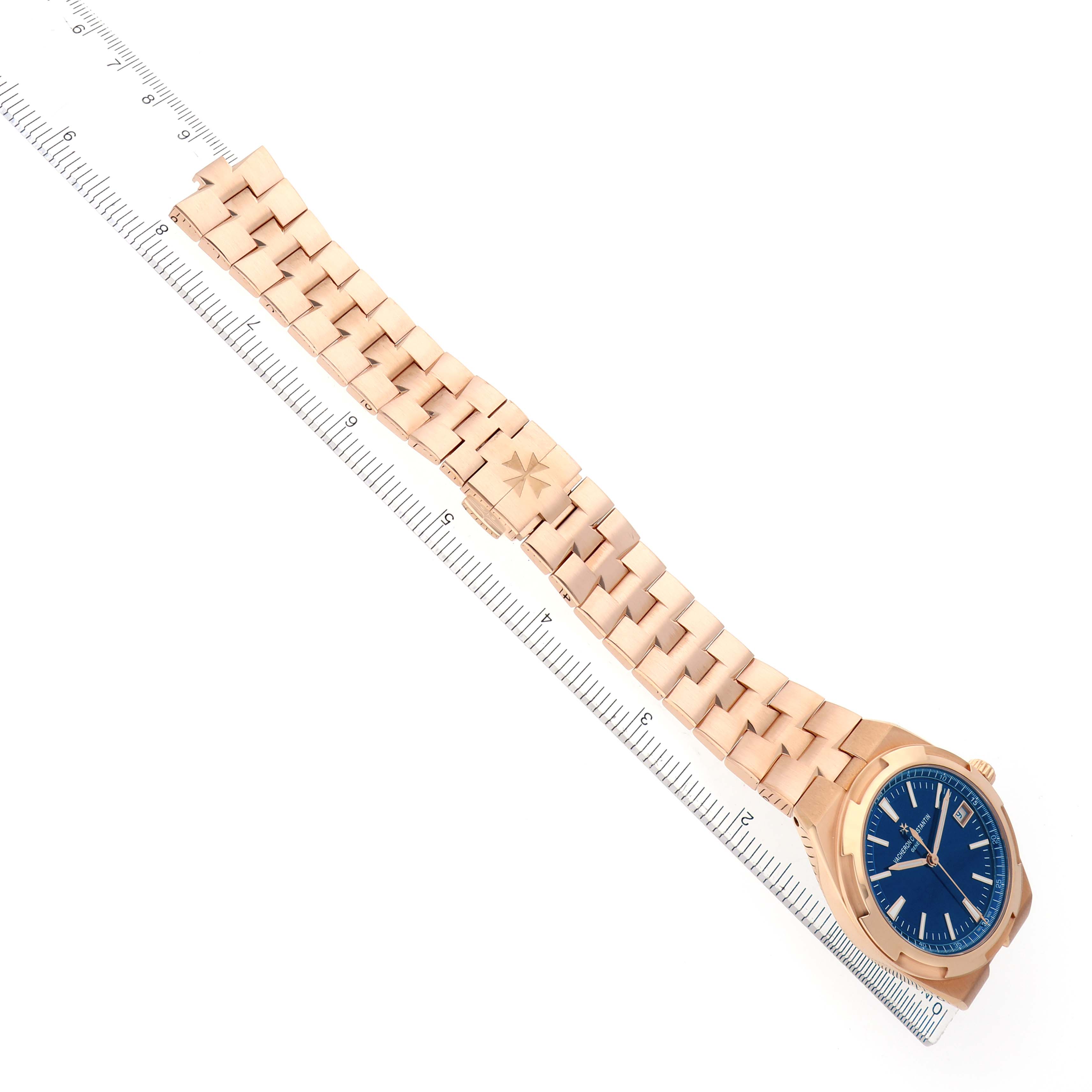 The Vacheron Constantin Overseas model 4500V men's watch is displayed from an overhead angle, showing its full bracelet and blue dial aligned with a ruler.