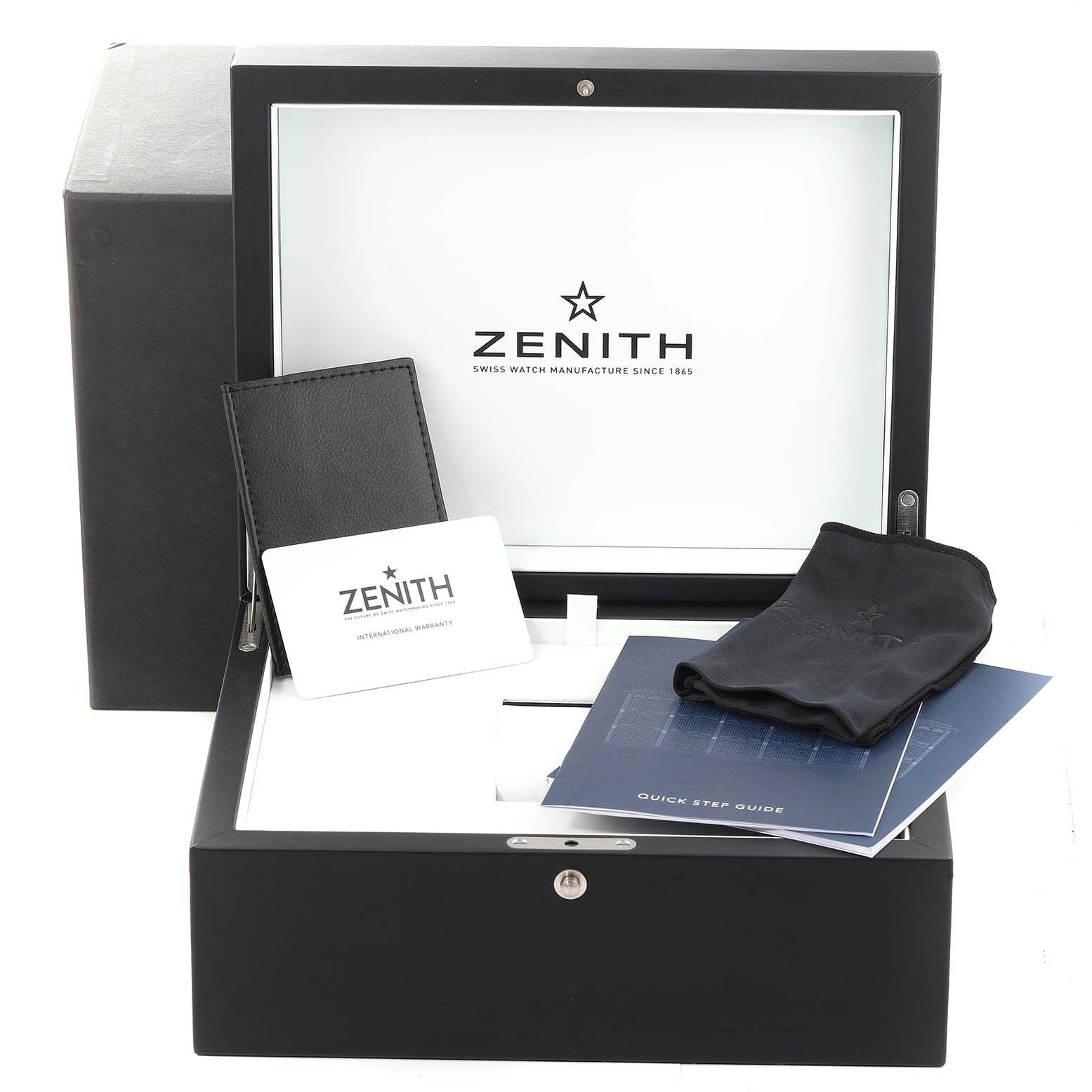 The image shows an opened Zenith Chronomaster 03.3100.3600/69.C823 Men's Stainless Steel White Dial 03.3100.3600/69.C823 Men's Stainless Steel White Dial watch box with manuals, a warranty card, a leather wallet, and a watch pouch inside.