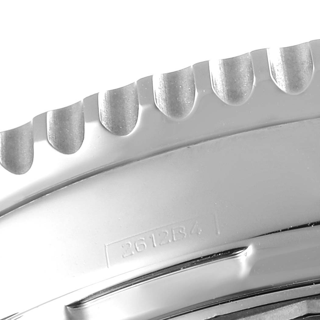 The image shows a close-up of the bezel from a Breitling Navitimer AB0123 Men's Stainless Steel Silver Dial AB0123 Men's Stainless Steel Silver Dial watch, highlighting its serrated edge and part of the serial number.