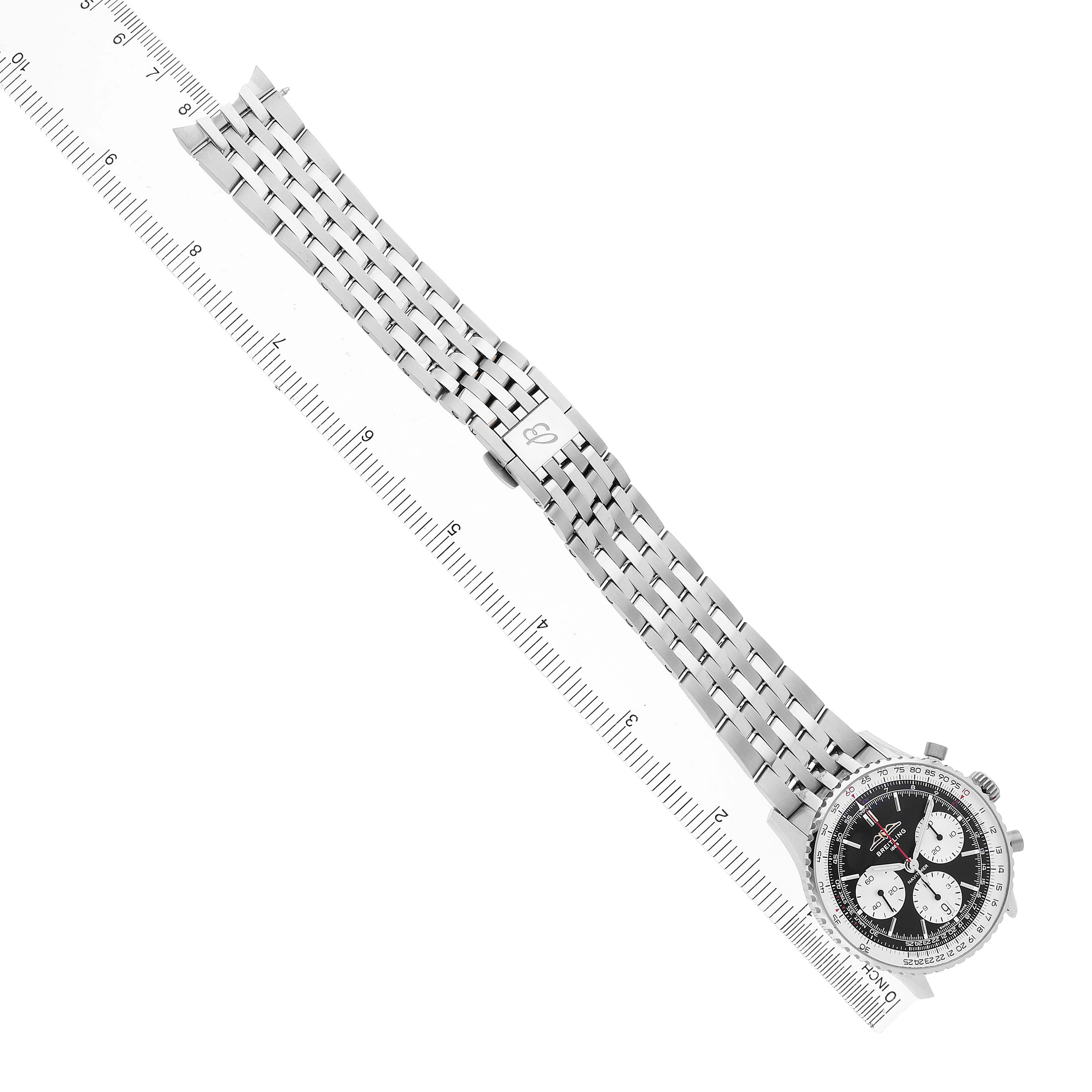 The Breitling Navitimer AB0139 Men's Stainless Steel Black Dial watch is shown from a top-down angle, displaying its full black dial and metal bracelet alongside a ruler.