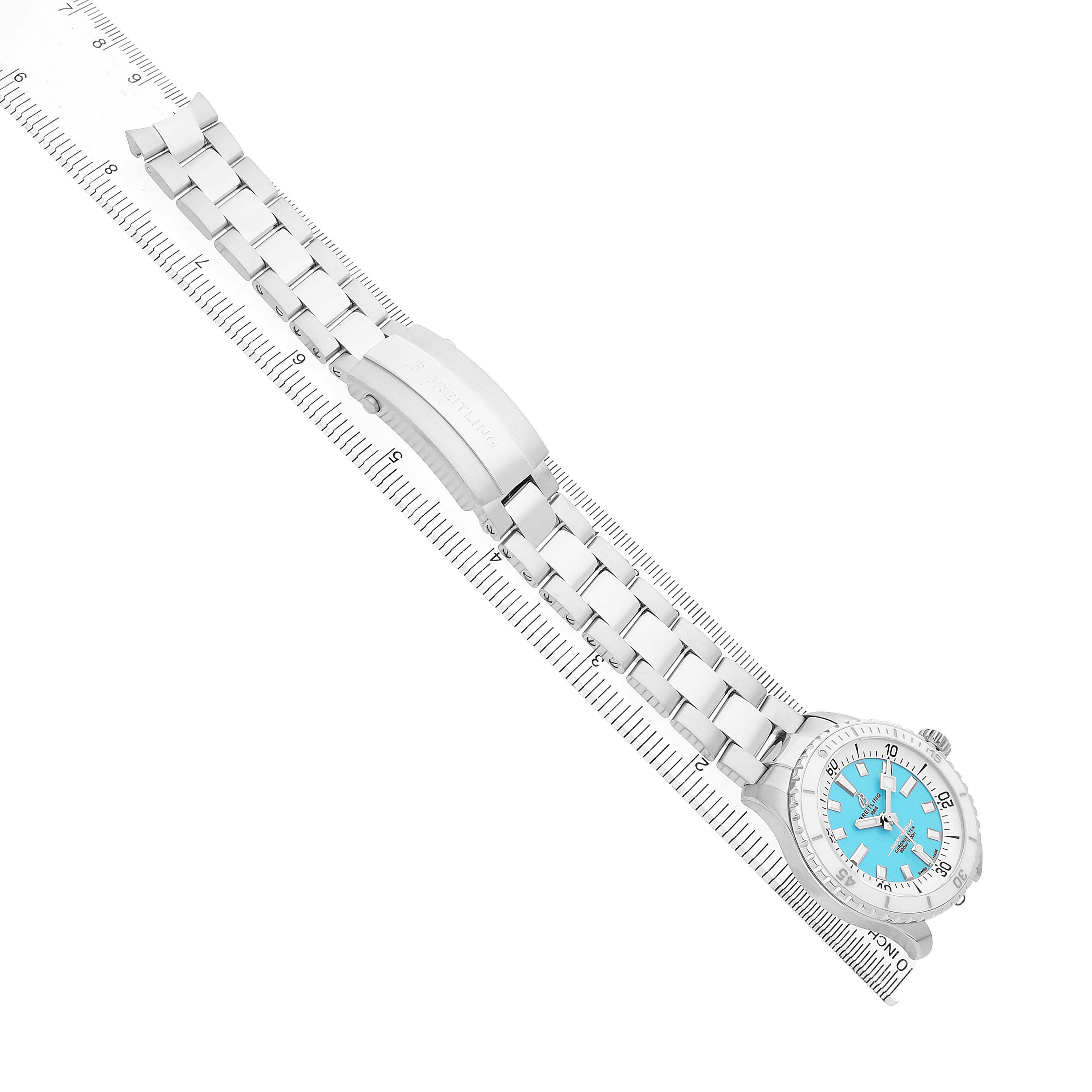 The Breitling A17377211C1A1 Women's Stainless Steel Blue Dial Superocean 36 A17377 is shown flat with a blue dial and steel bracelet, next to a ruler for size reference.