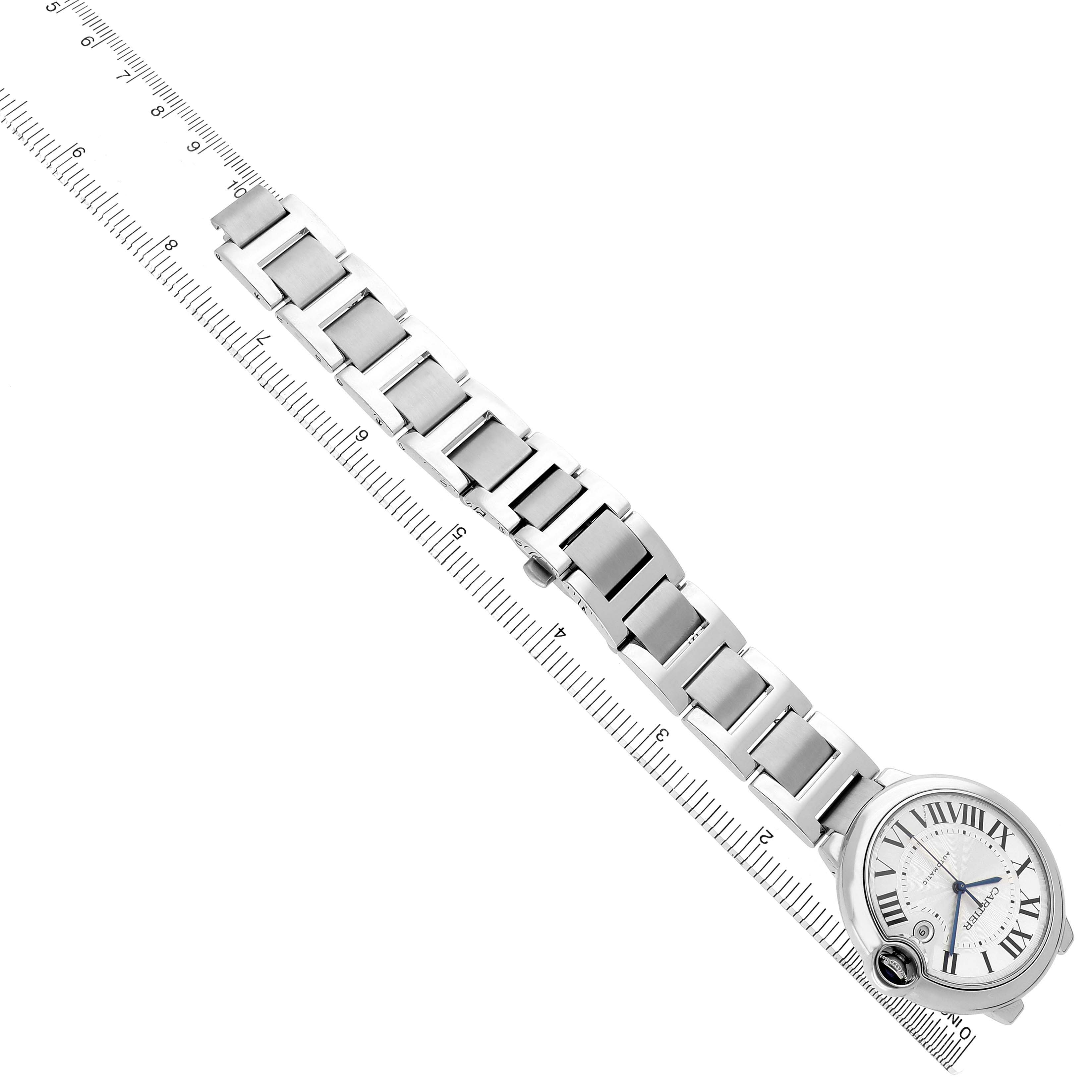 The Ballon Bleu model by Cartier is shown from a top-down angle, displaying the watch face, bracelet, and a ruler for scale.