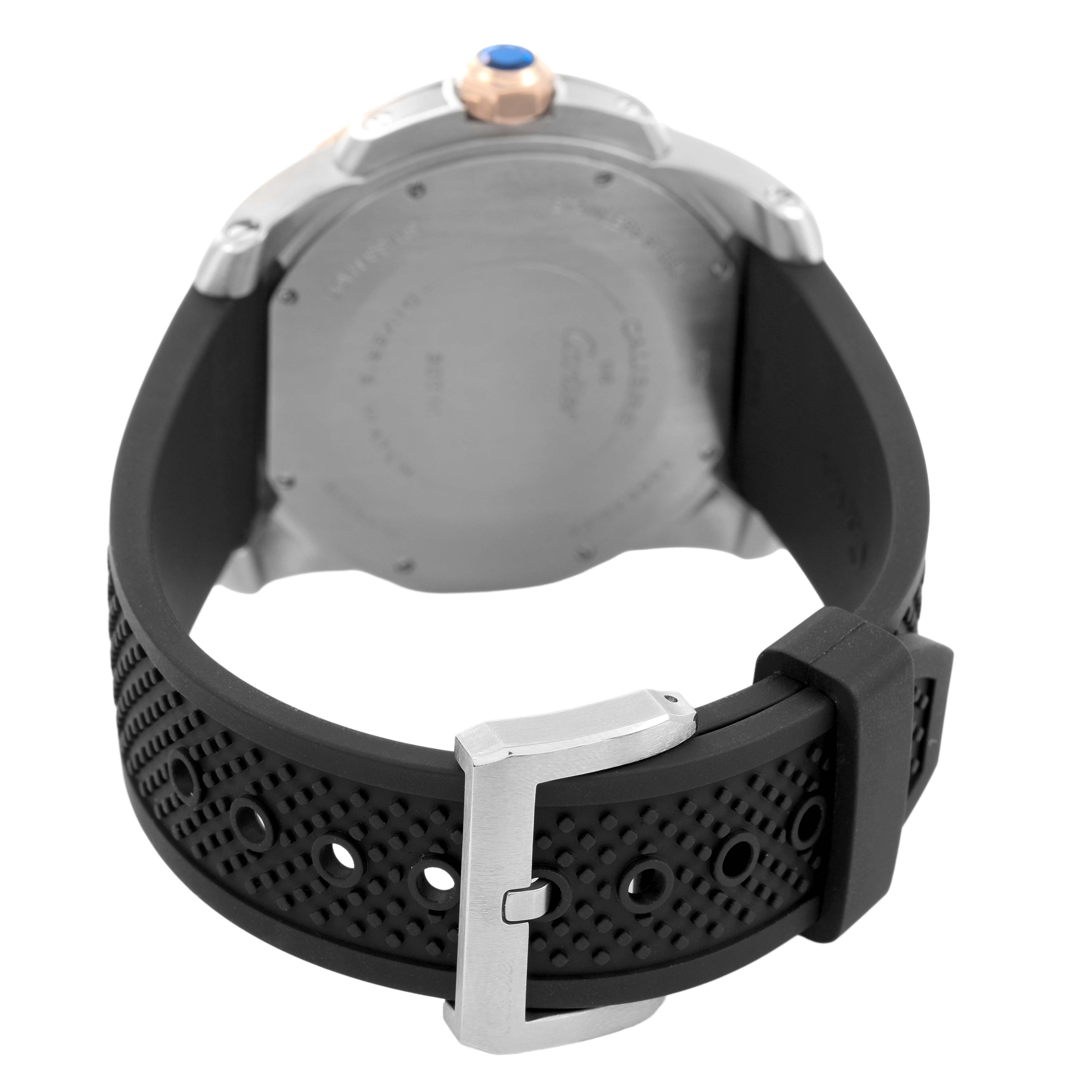 The image shows the back view of the Calibre de Cartier watch by Cartier, highlighting the case back, crown, and rubber strap with a buckle.