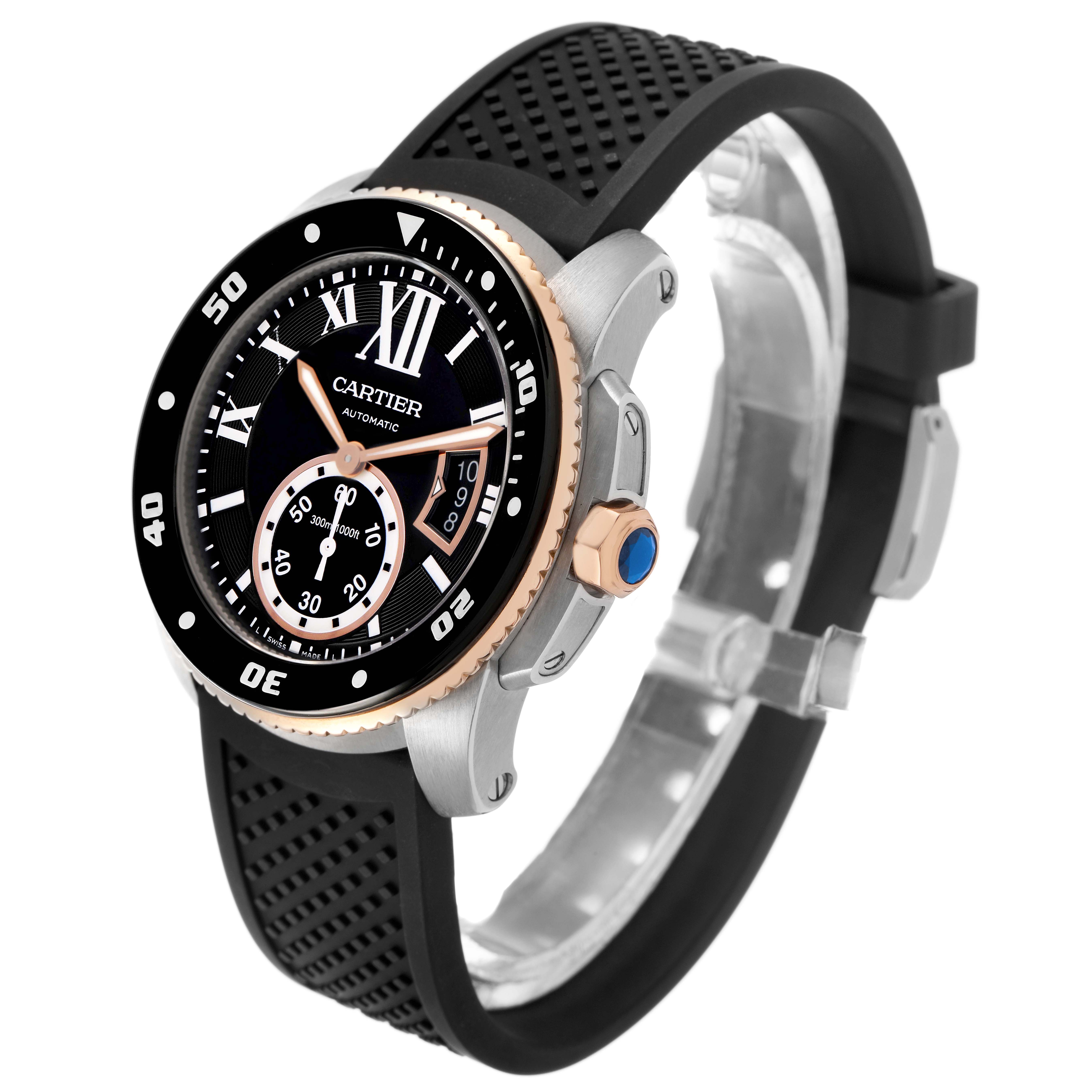 The Calibre de Cartier watch is shown at a slight angle highlighting the face, bezel, crown, and rubber strap.