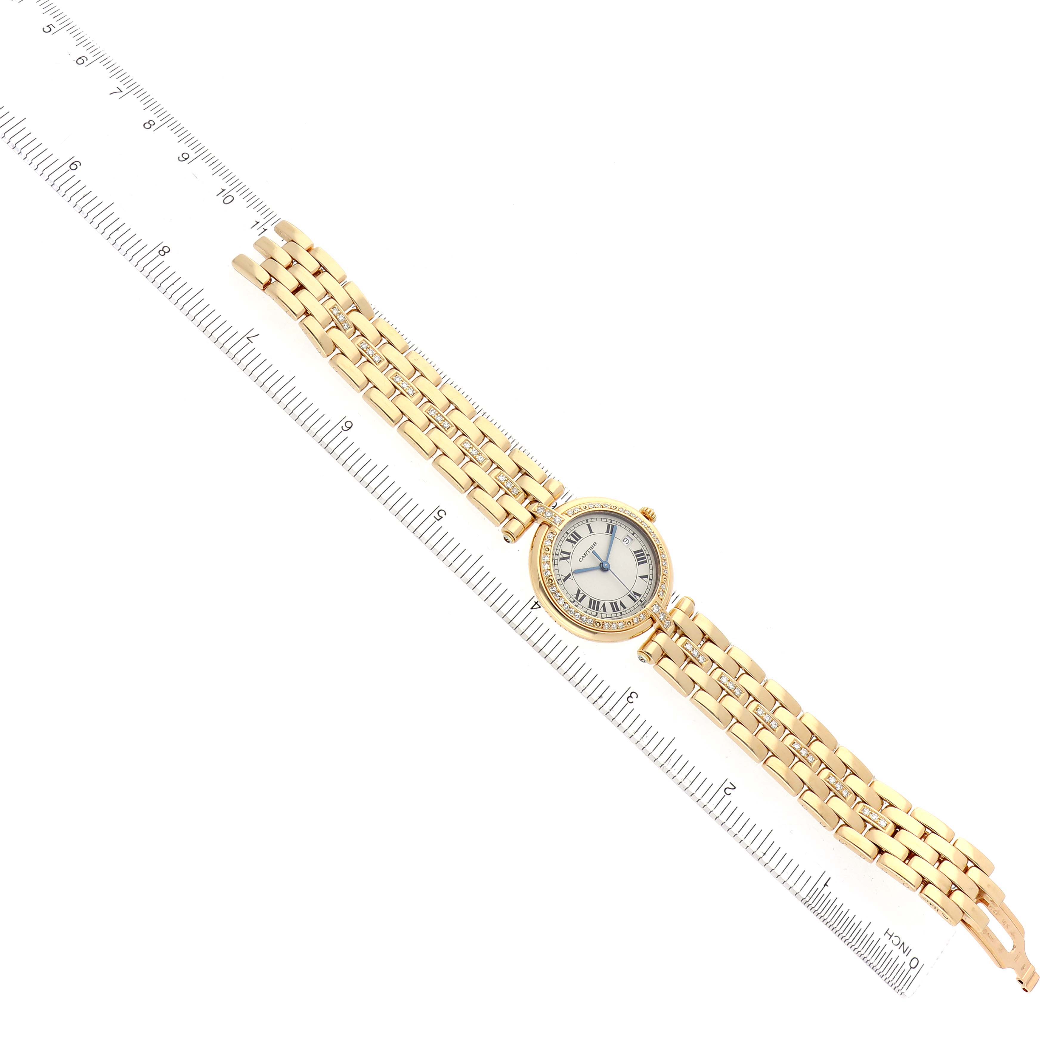 The image shows a Cartier Panthere men's watch, model number 884701FD, laid flat at an angle with a ruler beside it, displaying the face and gold bracelet.