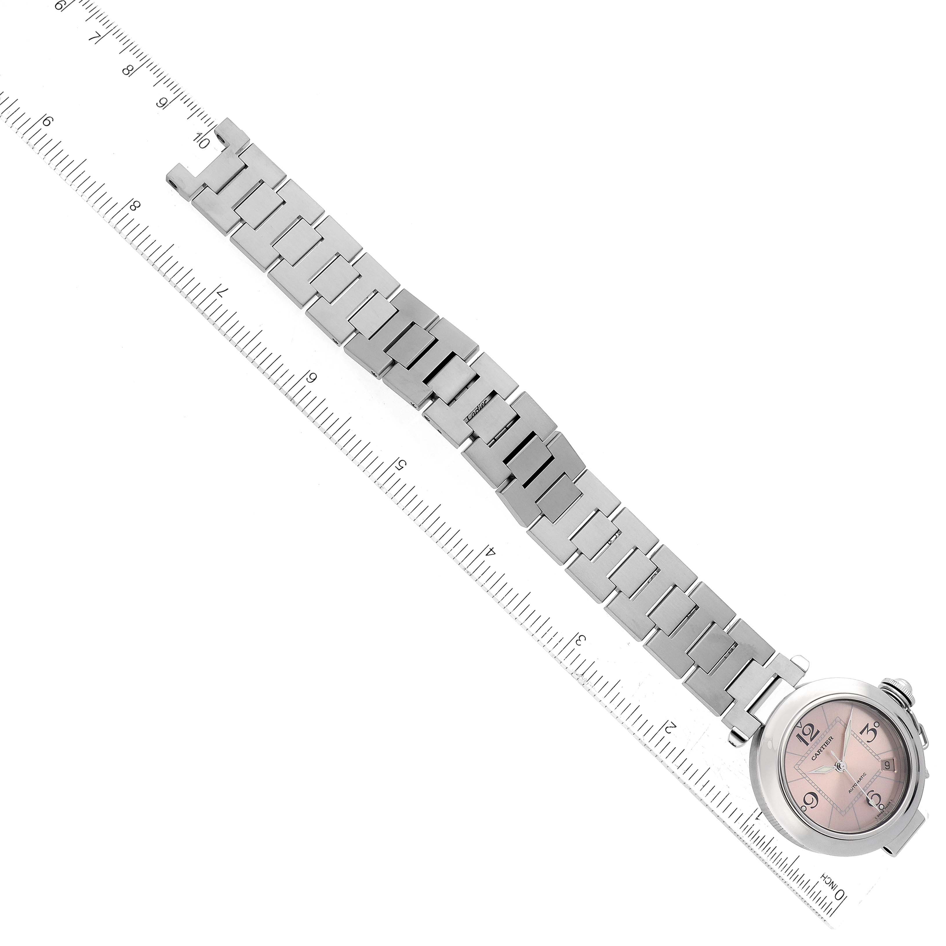 This image shows a top-down view of the Cartier Pasha W31075M7 Women's Stainless Steel Pink Dial W31075M7 Women's Stainless Steel Pink Dial watch, displaying the entire watch band and face alongside a ruler for size reference.