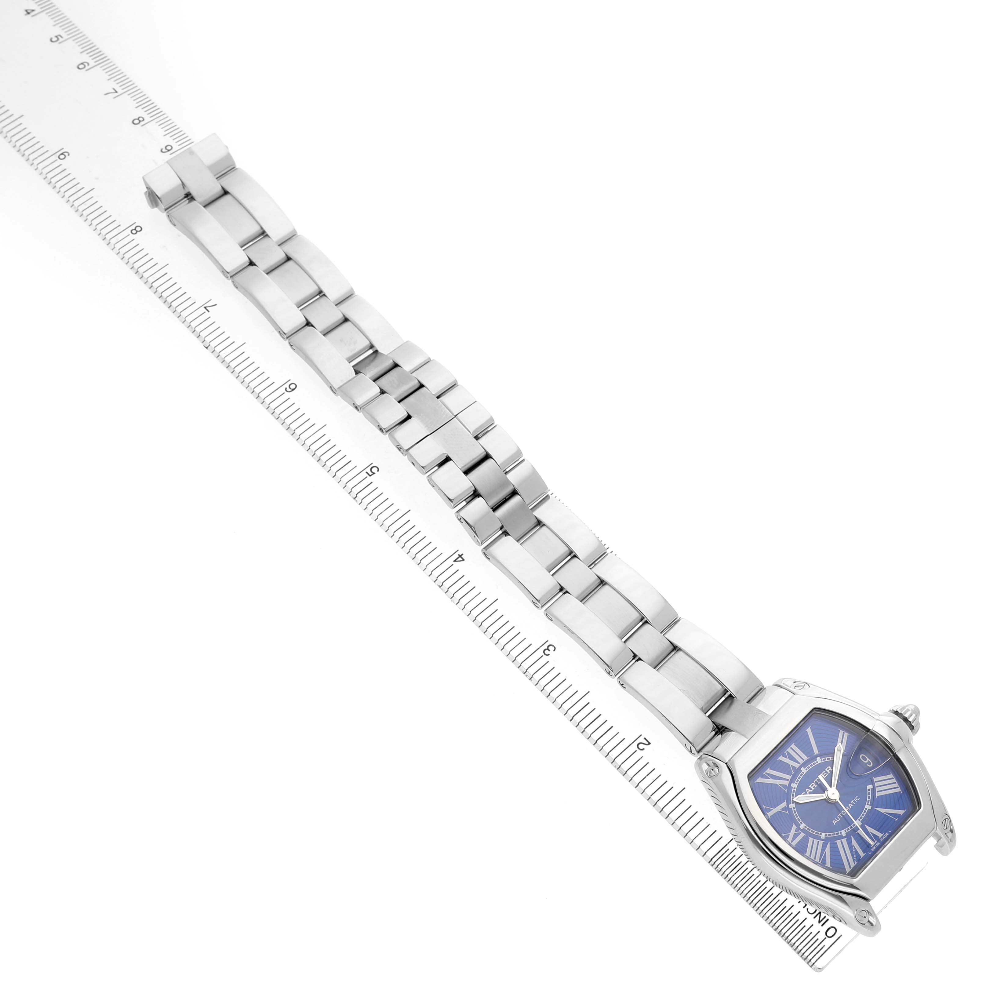 The Cartier Roadster W62048V3 Men's Stainless Steel Blue Dial watch is shown from an angled top view, displaying the full bracelet and the blue Roman numeral dial.