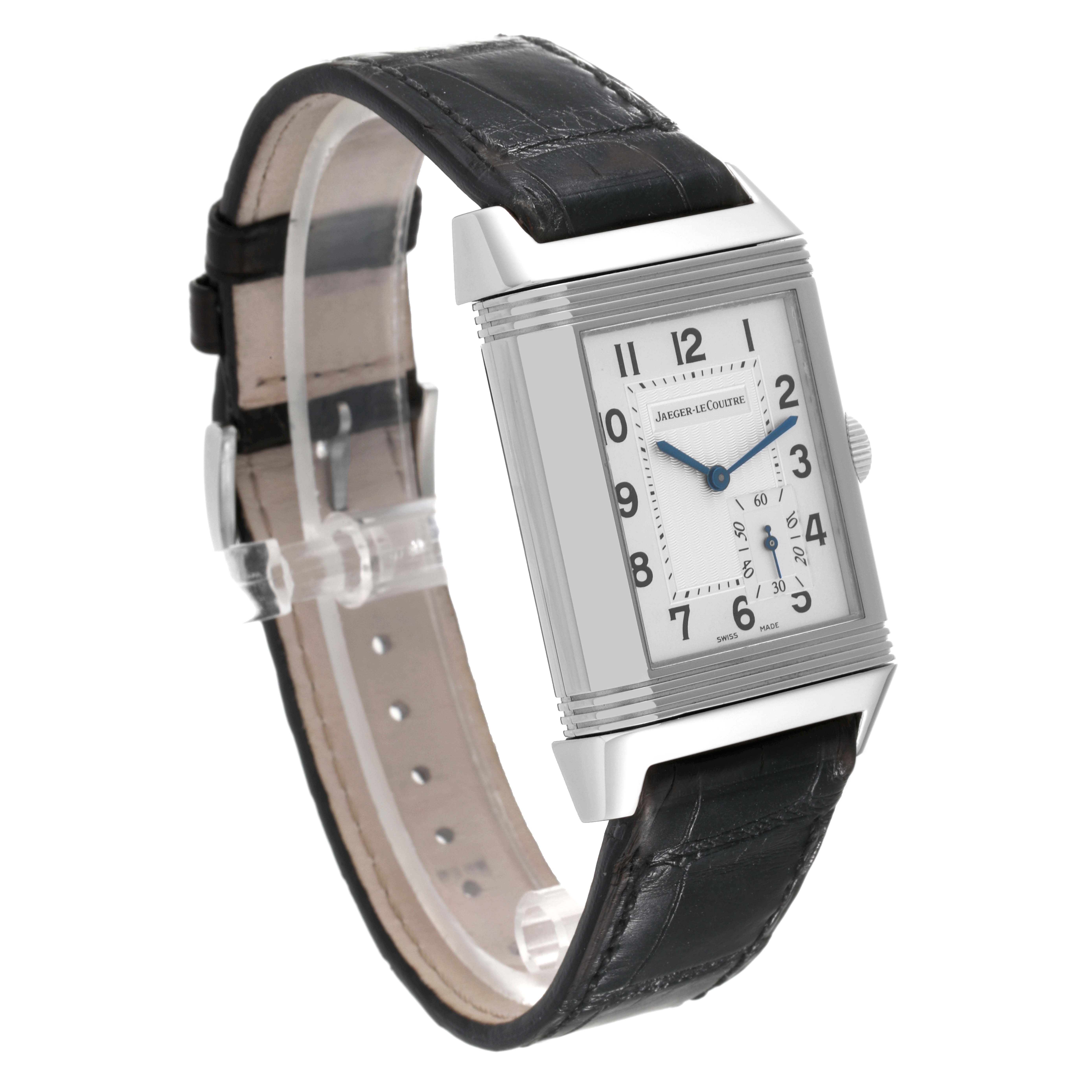 The Jaeger-LeCoultre Reverso watch is shown at an angle, highlighting its rectangular face and black leather strap.