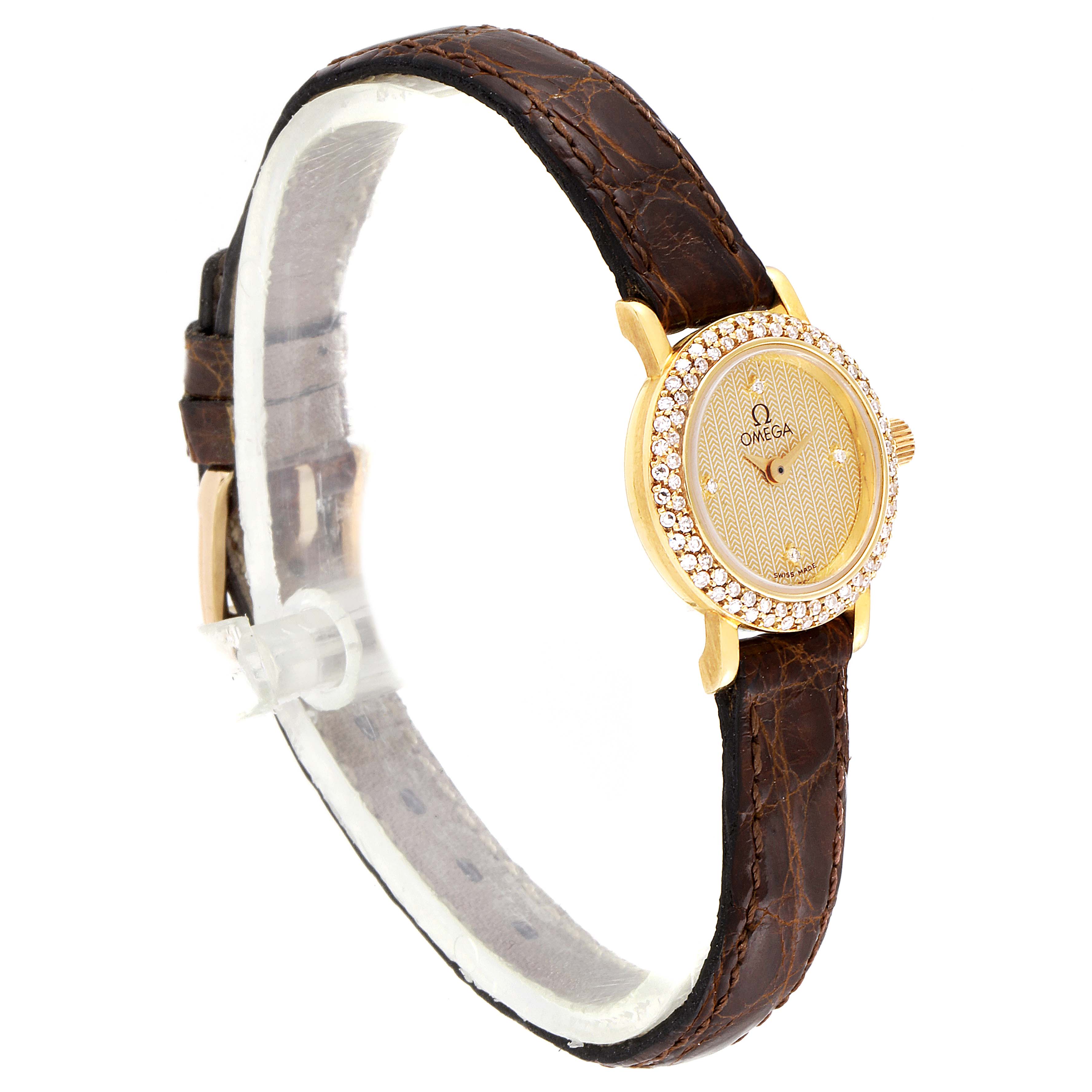 The image shows an Omega 1450 Women
s Yellow Gold Champagne Dial 1450 Women
s Yellow Gold Champagne Dial DeVille Mini Yellow Gold Diamond Cocktail Ladies Watch 1450 from a side angle, highlighting its face and strap.