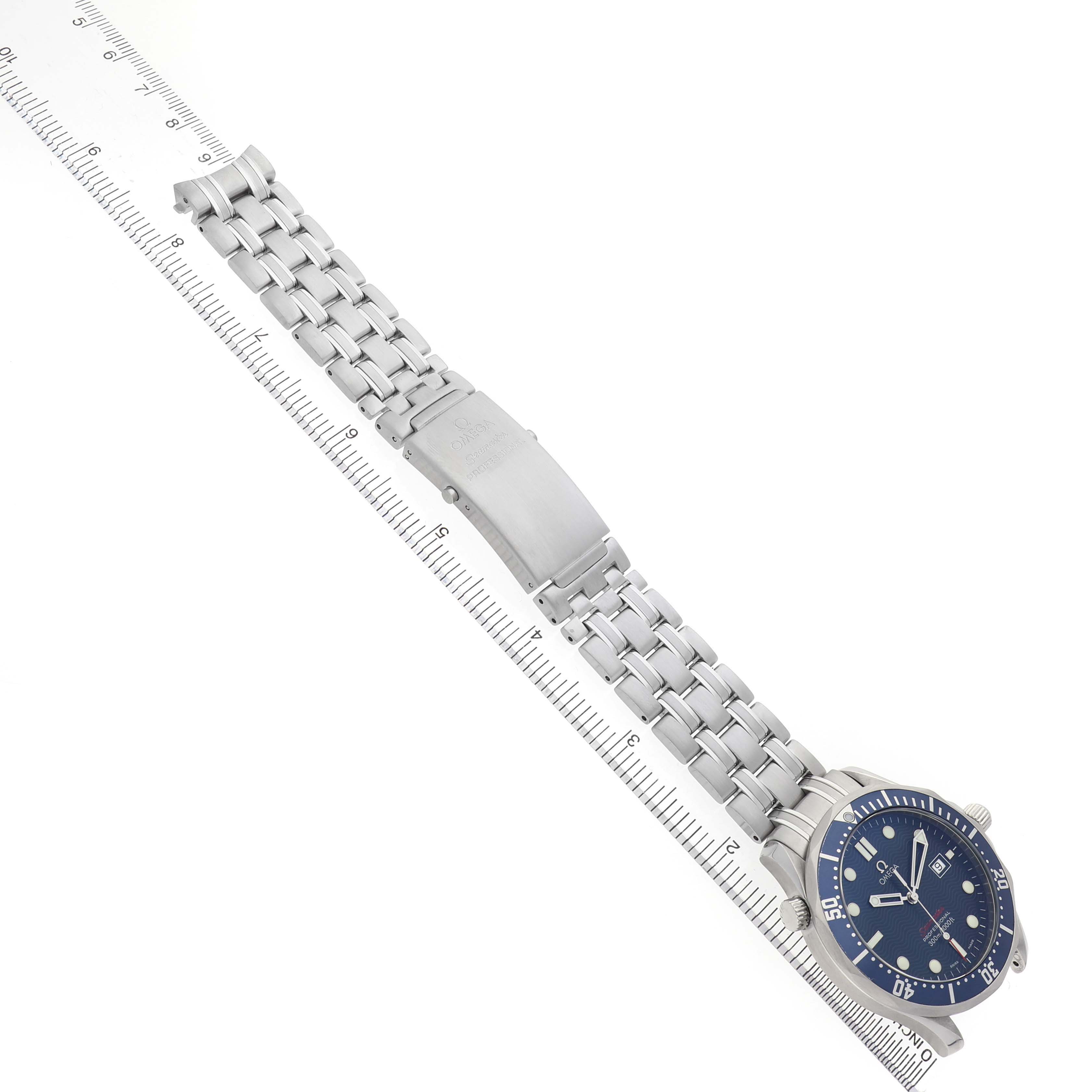 The image shows an Omega Seamaster 2221.80.00 Men's Stainless Steel Blue Dial watch with a full view of its face, bracelet, and clasp, aligned alongside a ruler.