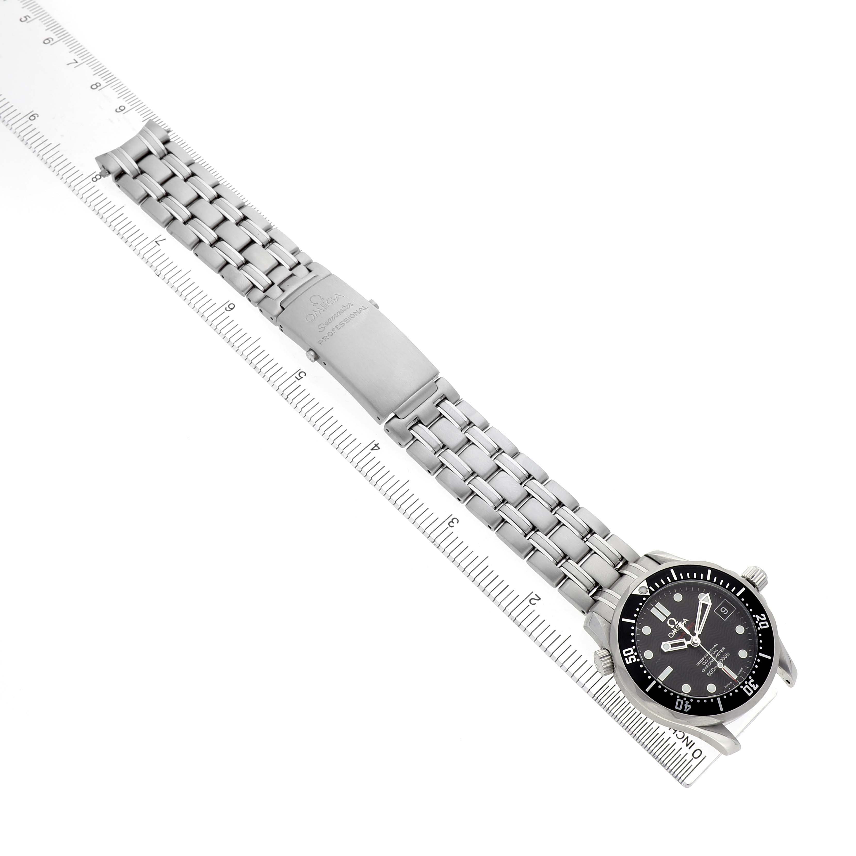 The Omega Seamaster 212.30.36.20.01.001 Men's Stainless Steel Black Dial watch is shown at a diagonal angle, featuring the face, bezel, crown, and full stainless steel bracelet next to a ruler.