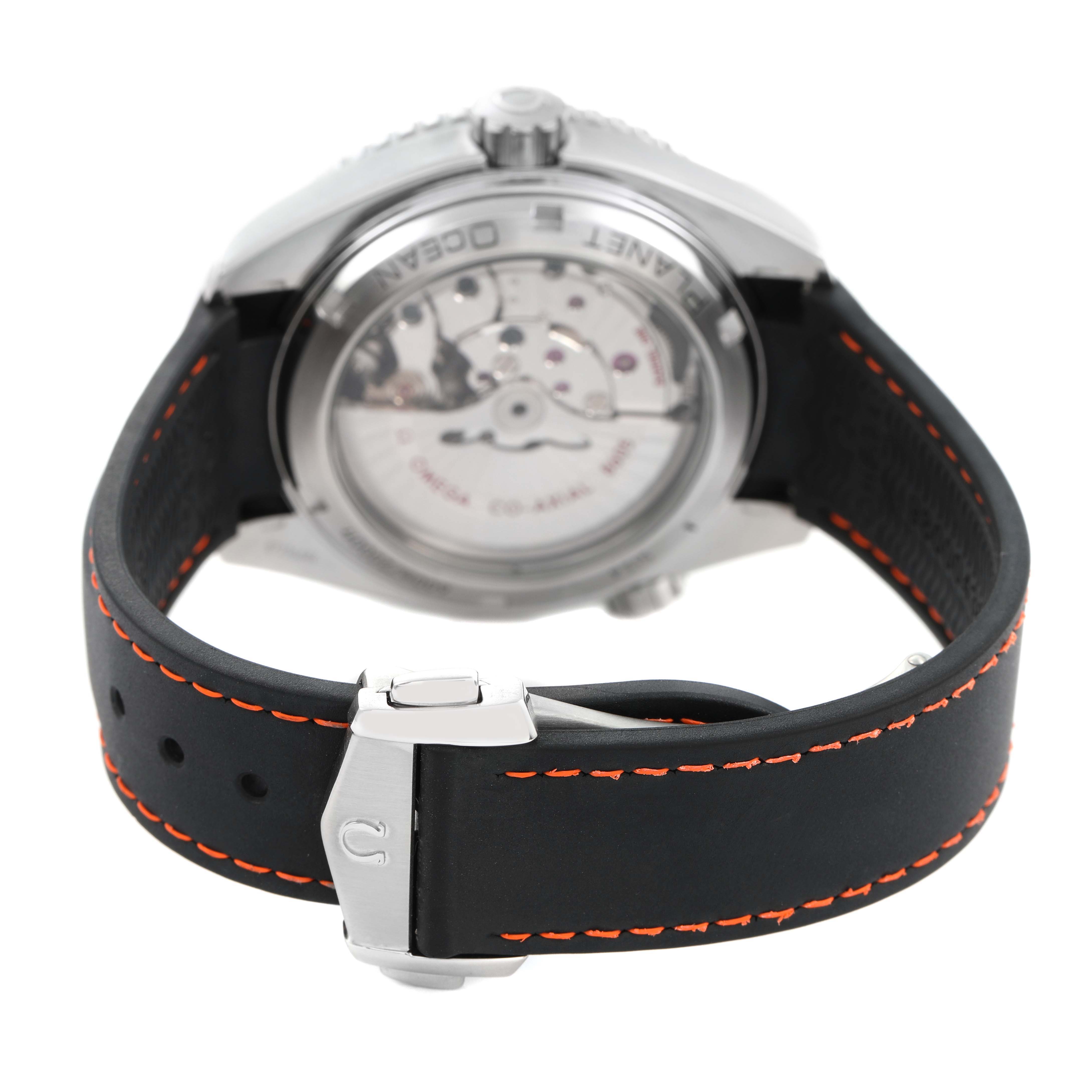 The Omega Planet Ocean 232.30.44.22.01.002 Men's Stainless Steel Black Dial watch is shown from the rear angle, focusing on the case back and strap with orange stitching.