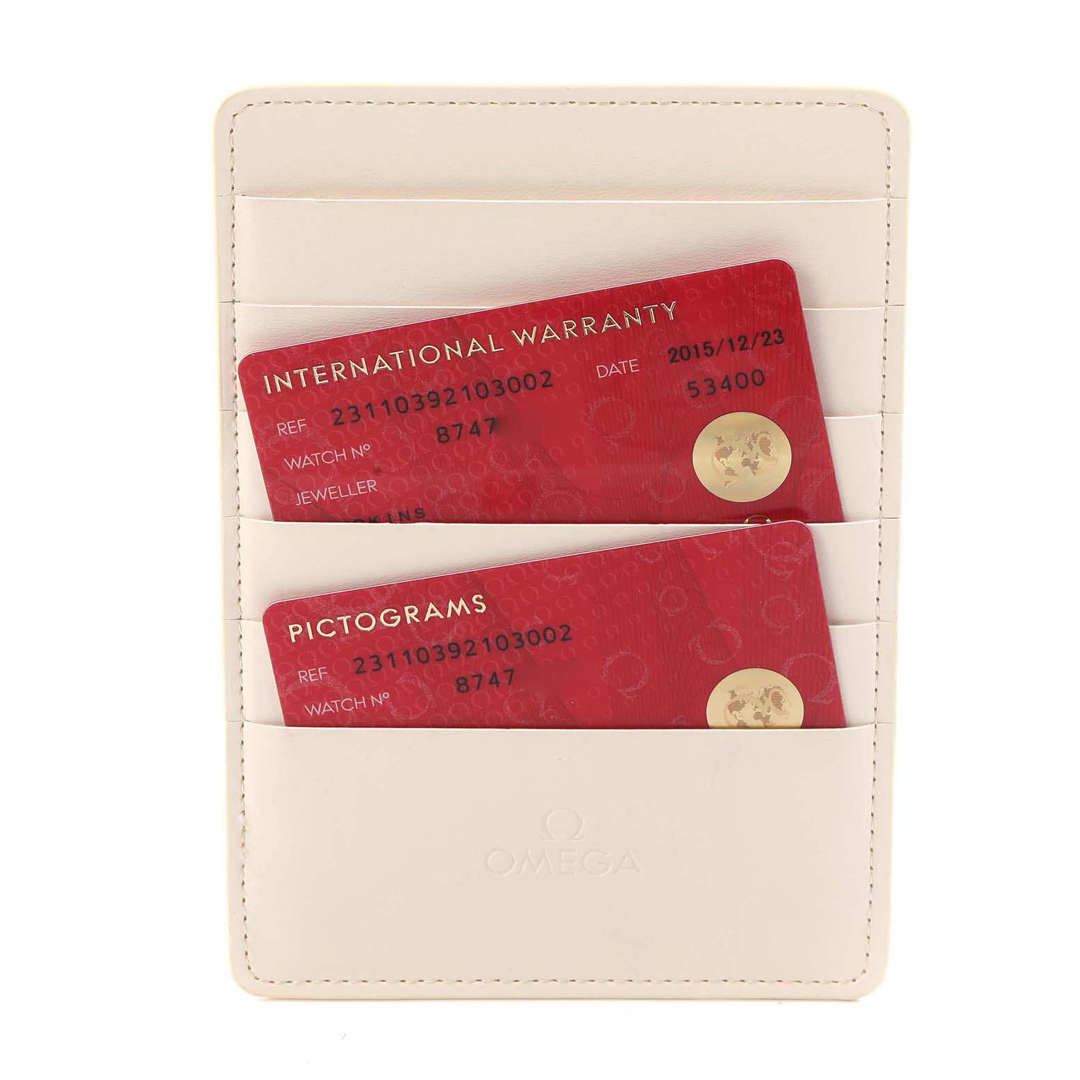 The image shows warranty and pictogram cards for an Omega Speedmaster, model 323.30.40.40.02.001, placed in a beige card holder.