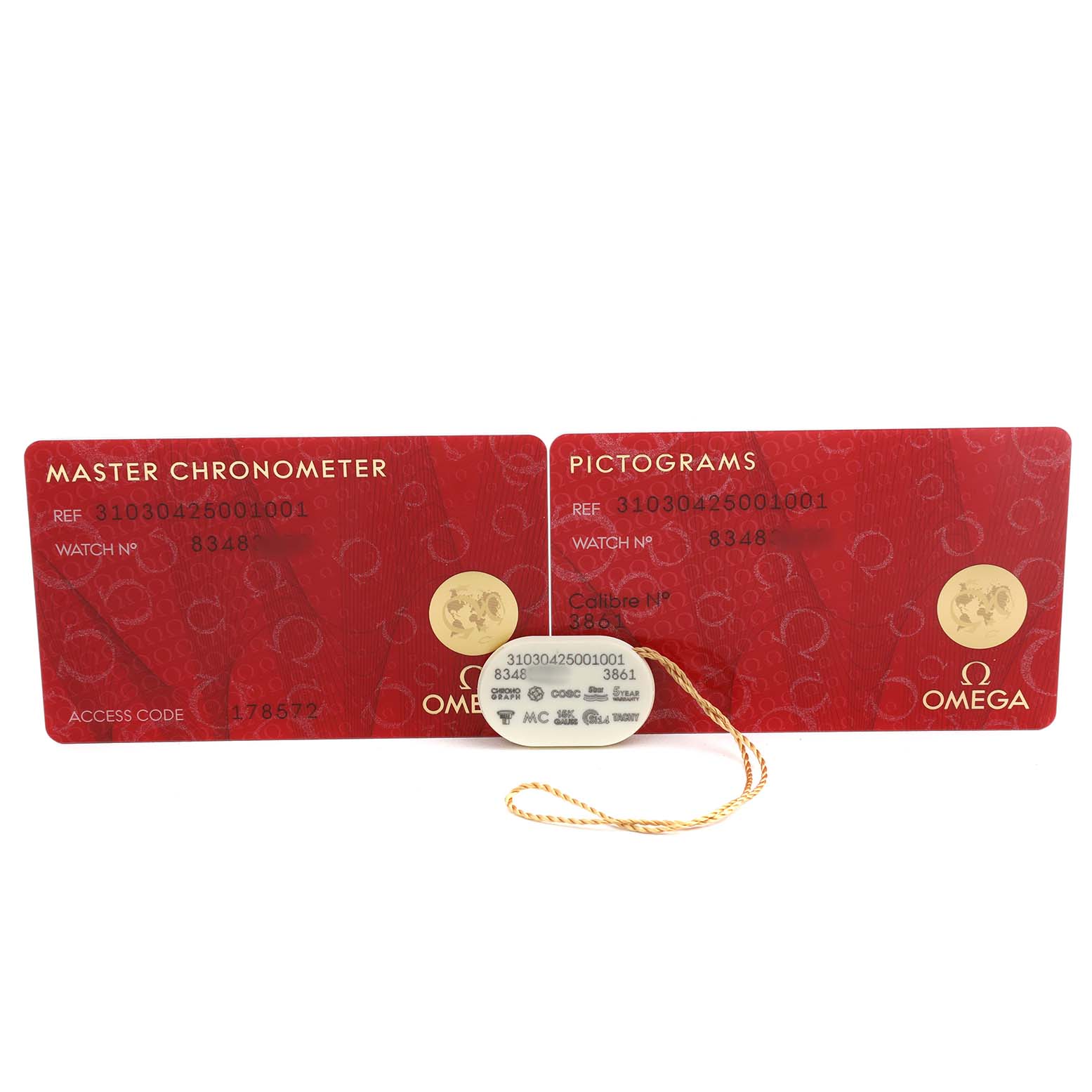 The image shows warranty and pictogram cards for the Omega Speedmaster 310.30.42.50.01.001 Men's Stainless Steel Black Dial, along with a tag, viewed from above.