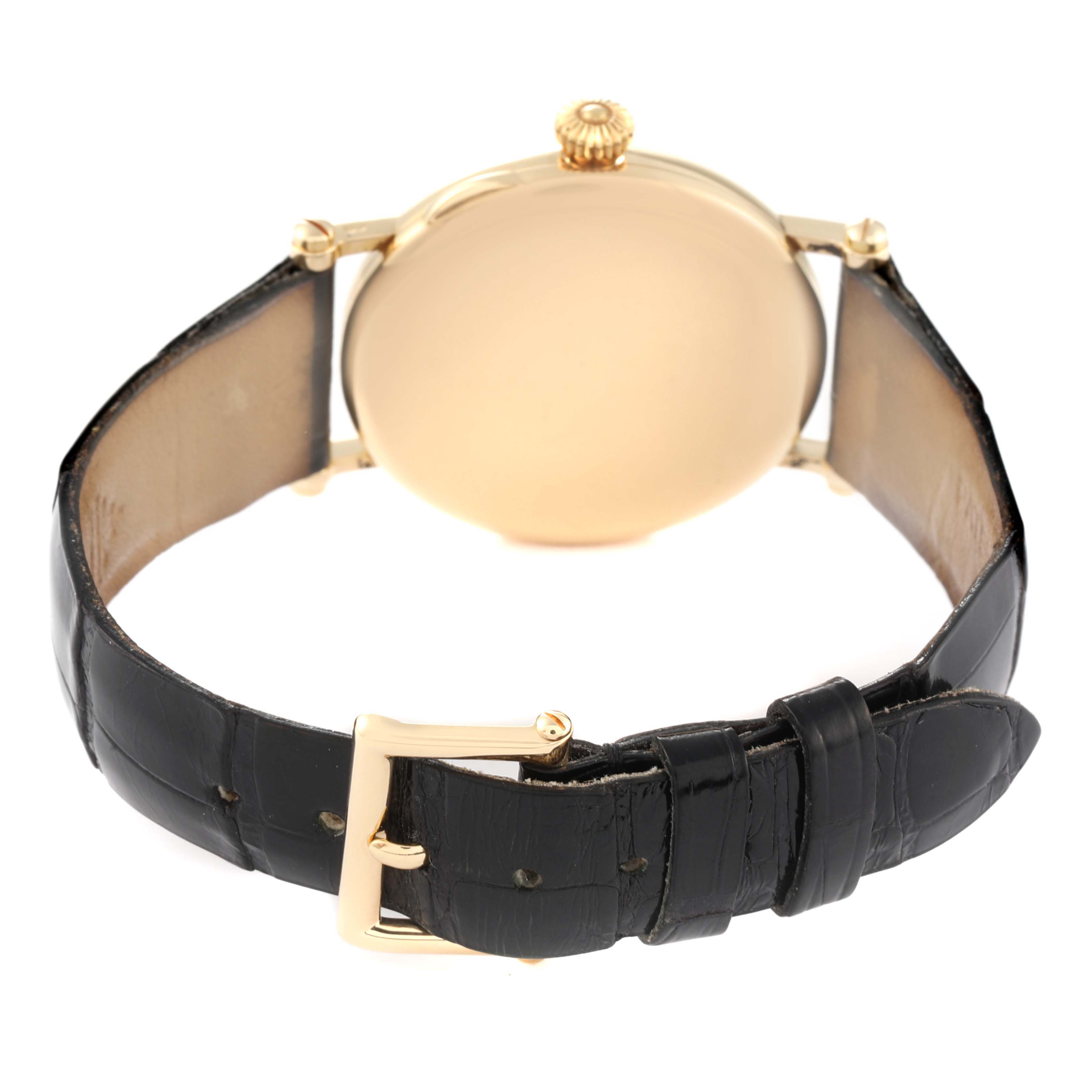 The image shows the back view of a Patek Philippe Calatrava 3960J Men's Yellow Gold White Dial 3960J Men's Yellow Gold White Dial watch with a black leather strap and a gold buckle.