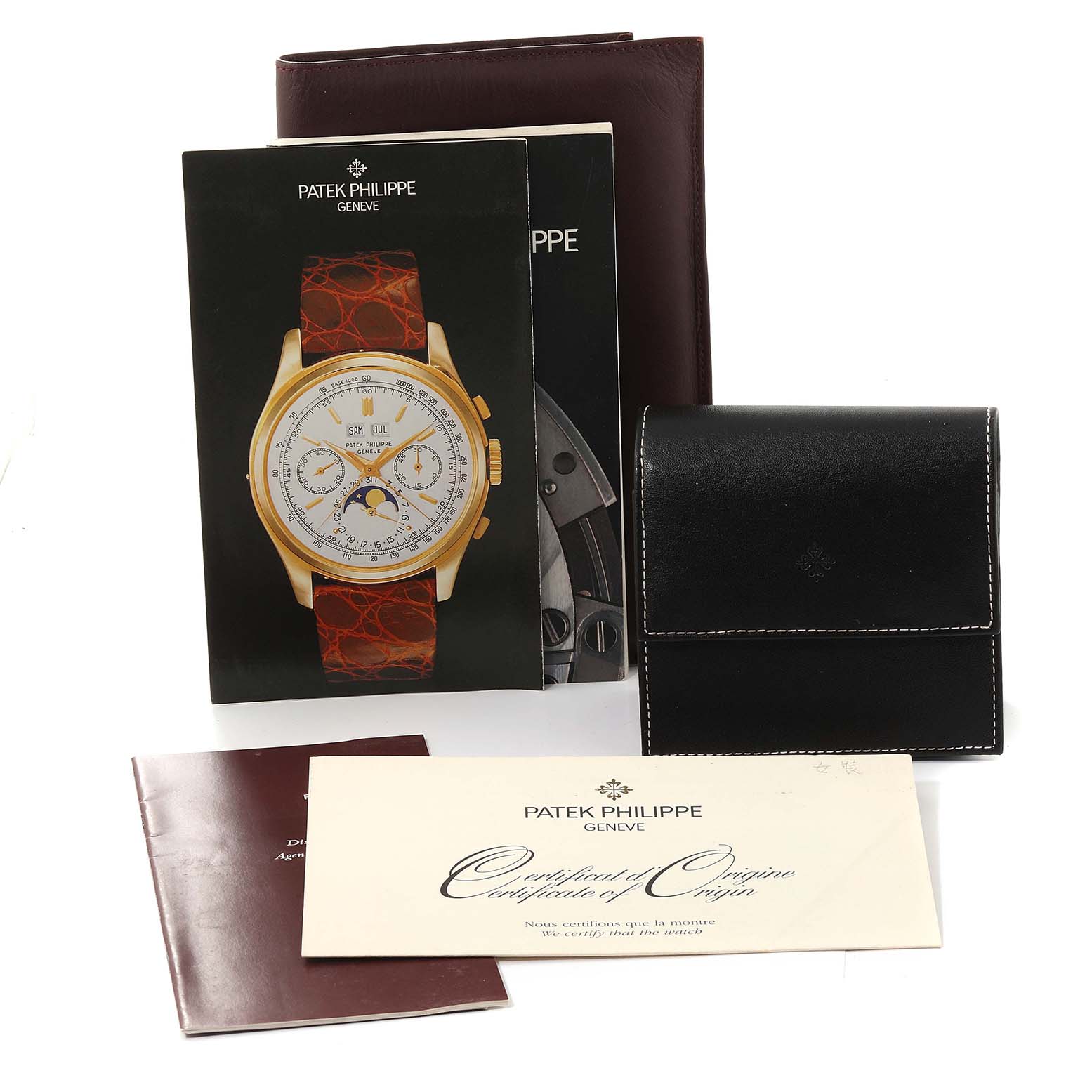 The image shows the Neptune model by Patek Philippe with its booklets, warranty card, and a black leather pouch, all viewed from the front.