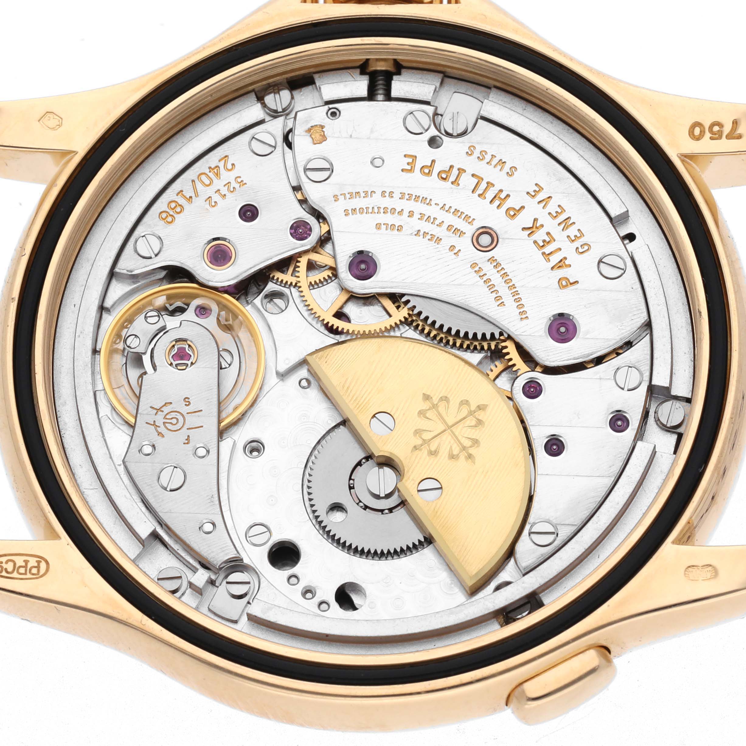 The image shows the intricate movement of a Patek Philippe Complications model 5110J-001 from the back, highlighting gears, jewels, and a gold rotor.
