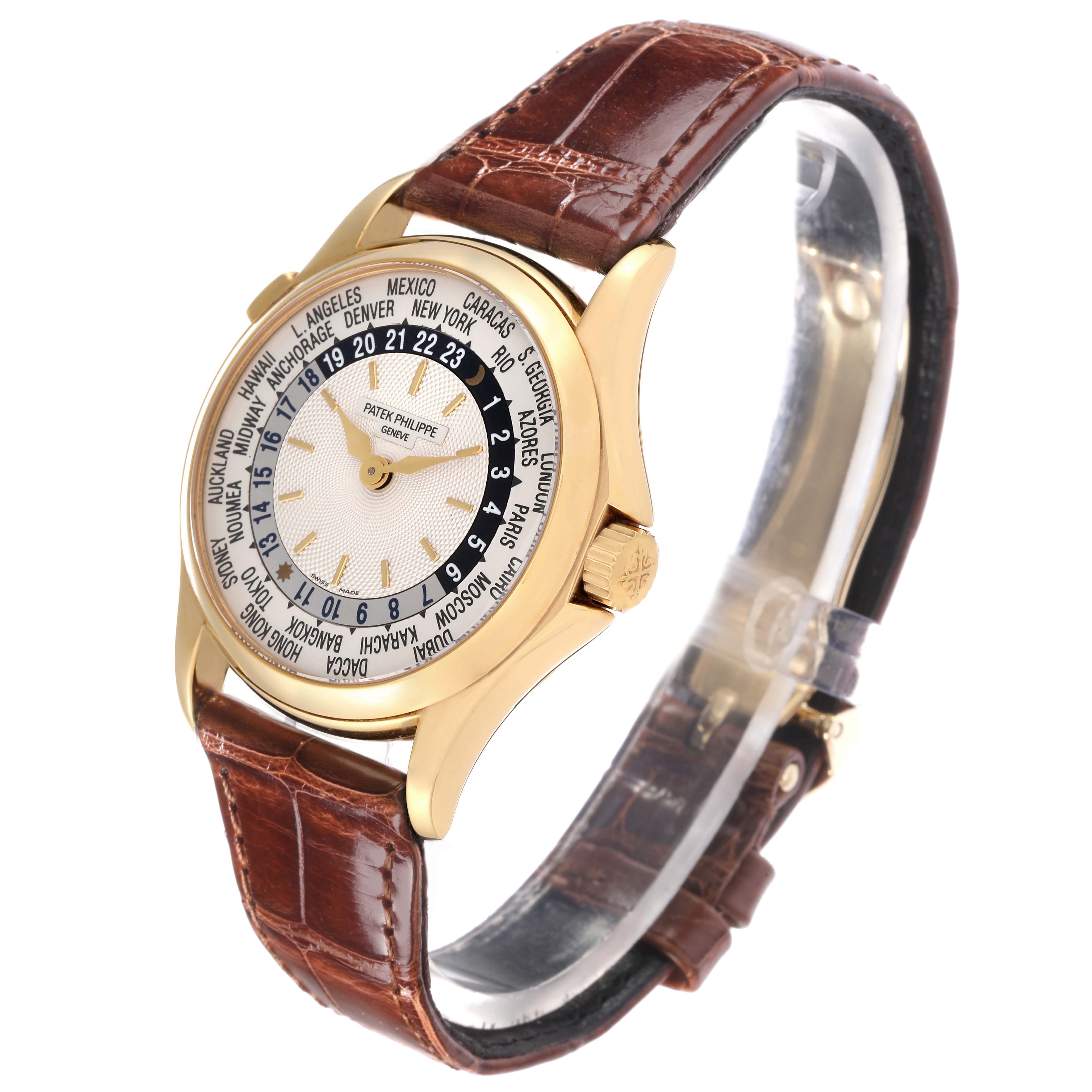 The Patek Philippe Complications model 5110J-001 is shown at a three-quarter angle, highlighting the face, world time dial, and brown leather strap.