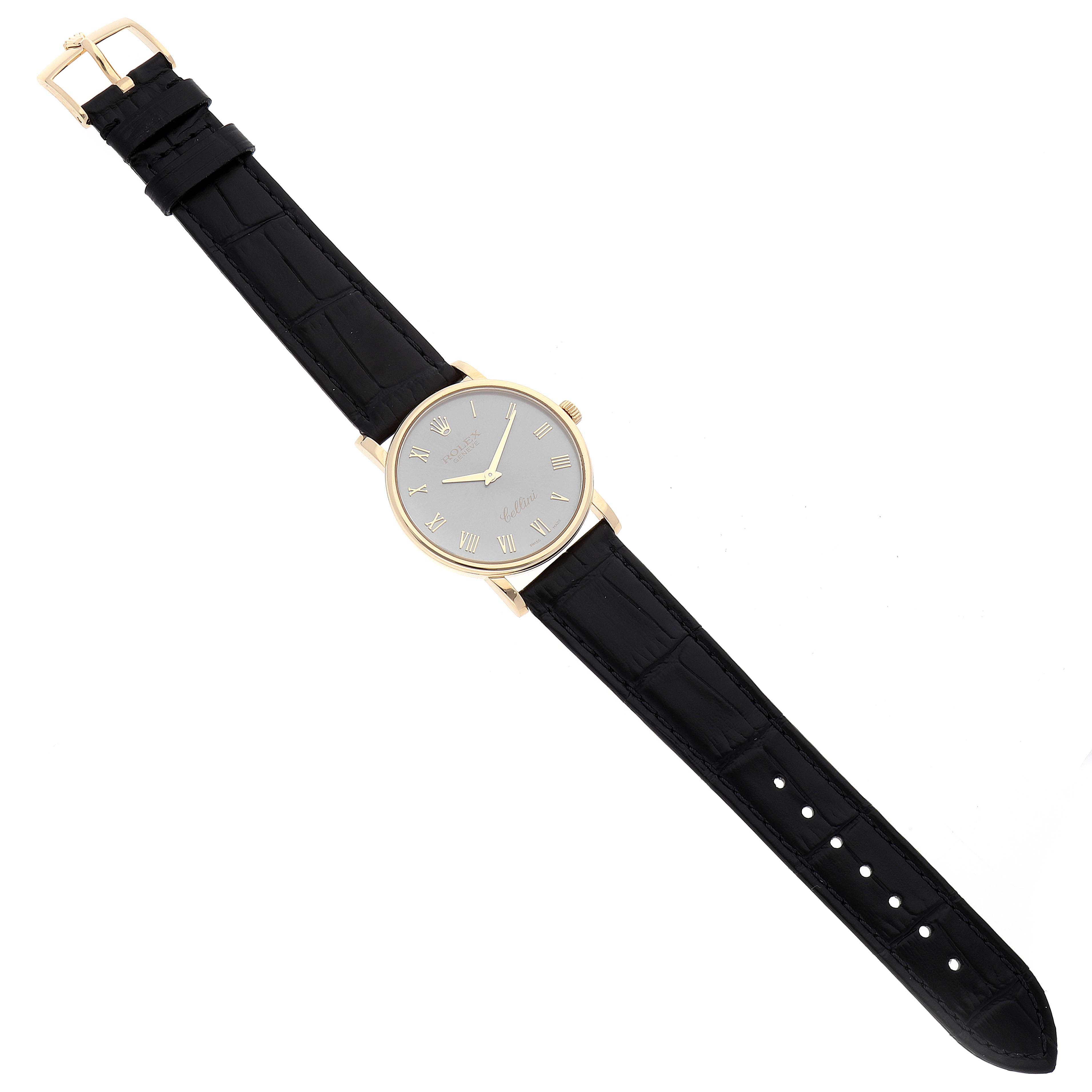 The Cellini model by Rolex is shown from a top-down angle, displaying the dial, hands, case, crown, and black leather strap.