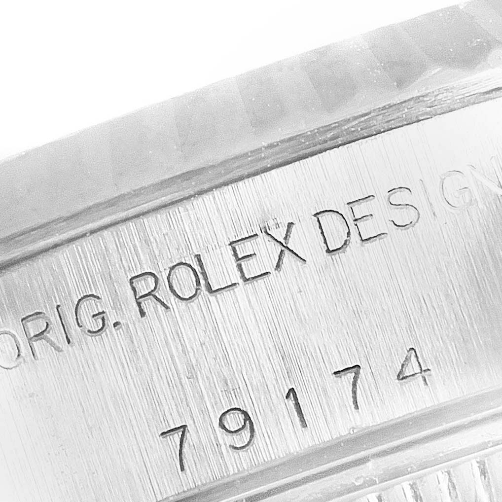 This image shows a close-up of the engraved case side of a Rolex Datejust 79174 Women
s Stainless Steel White Dial 79174 Women
s Stainless Steel White Dial, displaying "ORIG. ROLEX DESIGN" and the serial number.