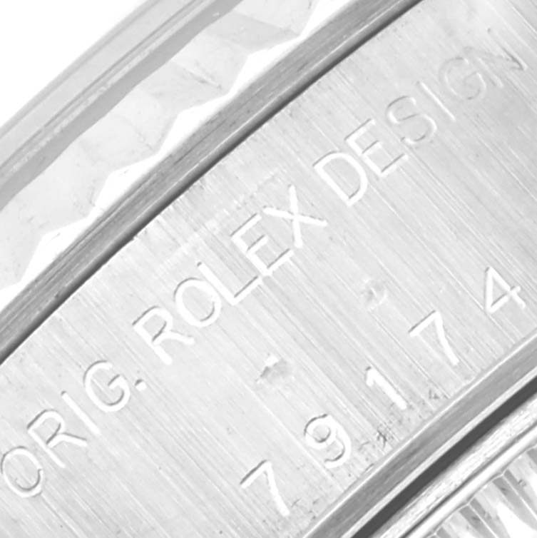 The image shows a close-up view of the side of a Rolex Datejust 79174 Women
s Stainless Steel Silver Dial 79174 Women
s Stainless Steel Silver Dial watch, highlighting the engraving "ORIG. ROLEX DESIGN" and the model number.