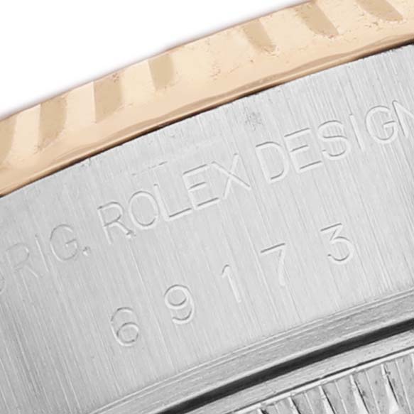 The image shows a close-up of the case side of a Rolex Datejust 69173 Women's Stainless Steel Champagne Dial, featuring engraved branding and design numbers.