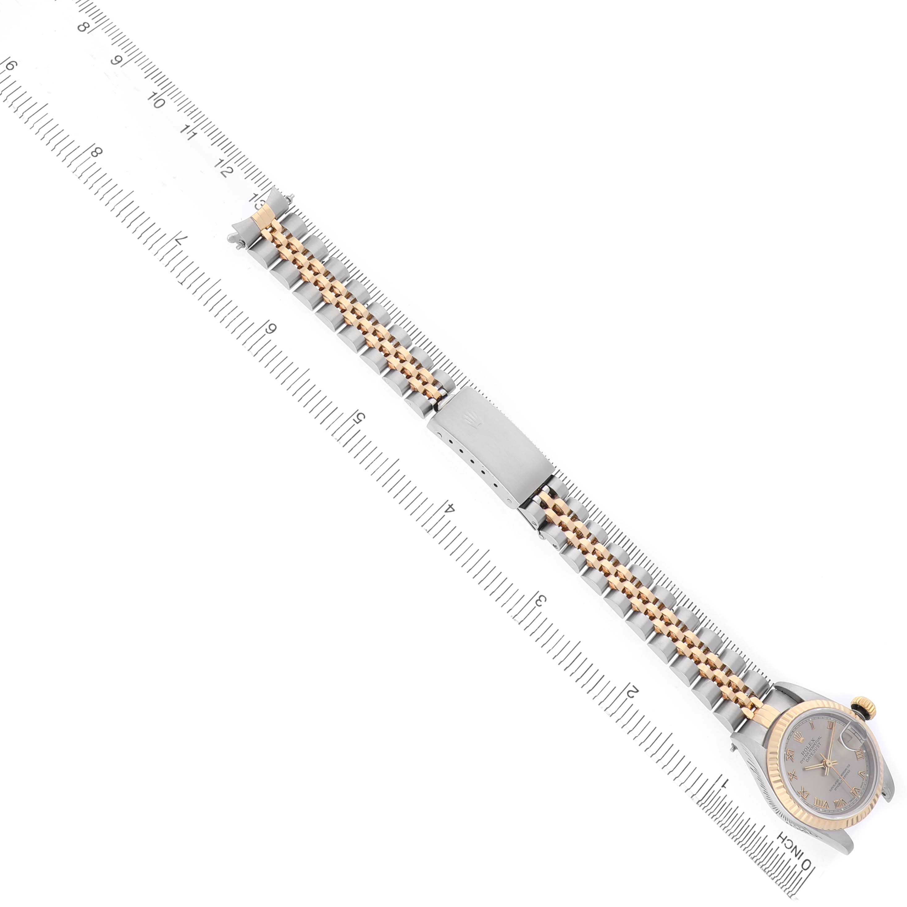 The Rolex Datejust 69173 Women's Stainless Steel Grey Dial watch is shown from an overhead angle, highlighting its face, bezel, and full bracelet alongside a ruler.