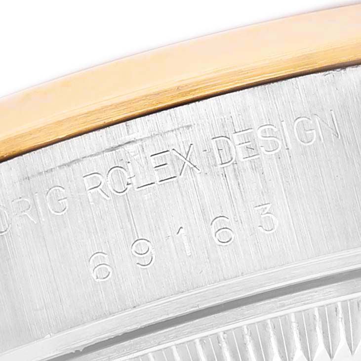 The image shows a close-up of the side of a Rolex Datejust 79163 Women's Steel and Gold (two tone) Grey Dial, focusing on the engraved serial and design numbers.