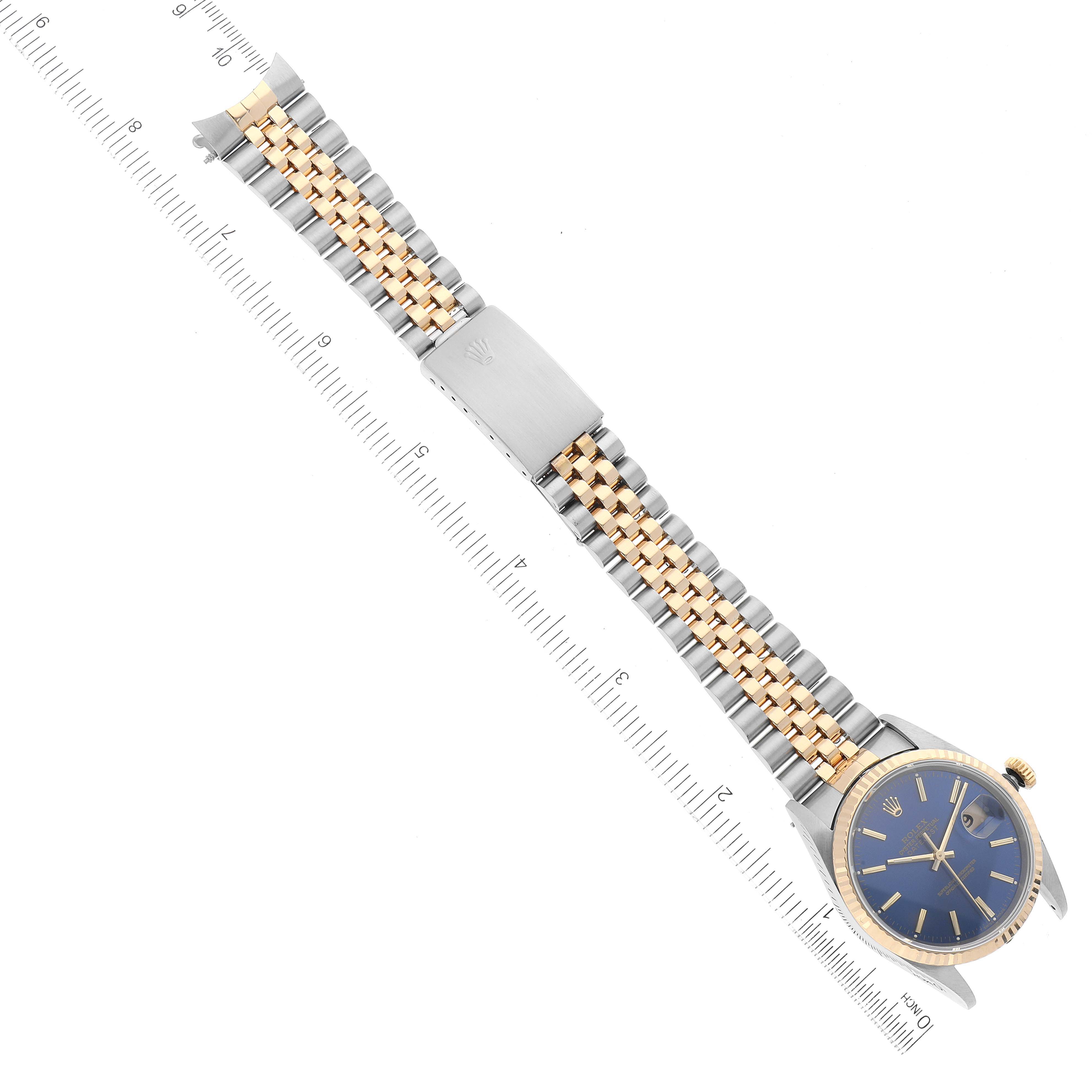 The image shows a Rolex Datejust 16233 Men's Steel and Gold (two tone) Blue Dial 16233 Men's Steel and Gold (two tone) Blue Dial watch displayed flat with a measurement ruler beside it.