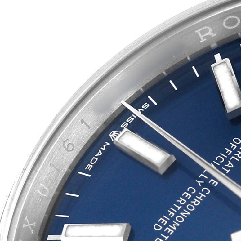 The image shows a close-up of the Rolex Datejust 126200 Men's Stainless Steel Blue Dial watch's dial and bezel, featuring indices and part of the "Swiss Made" text.