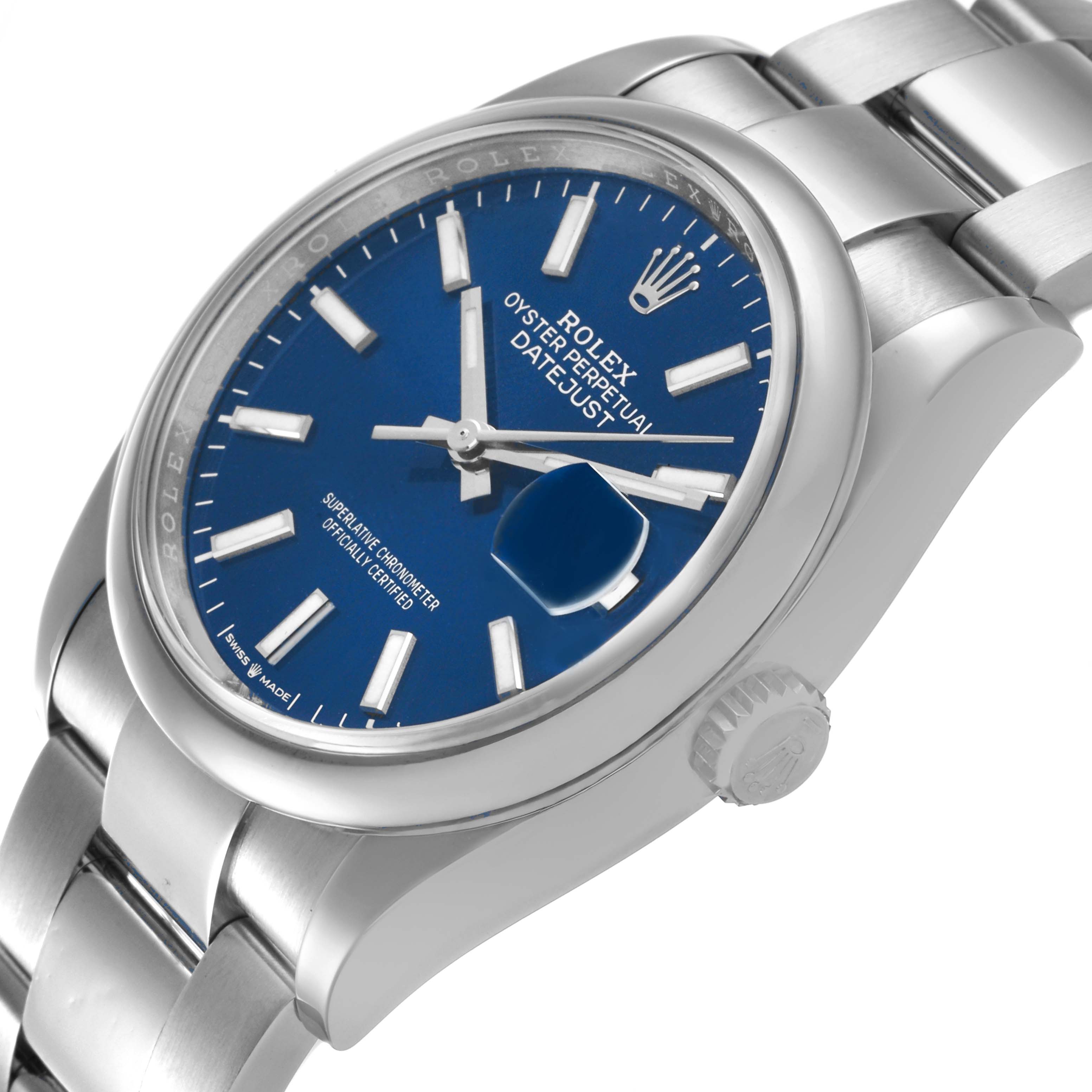 The Rolex Datejust 126200 Men's Stainless Steel Blue Dial watch is shown at an angled side view, highlighting the face, bezel, crown, and part of the bracelet.