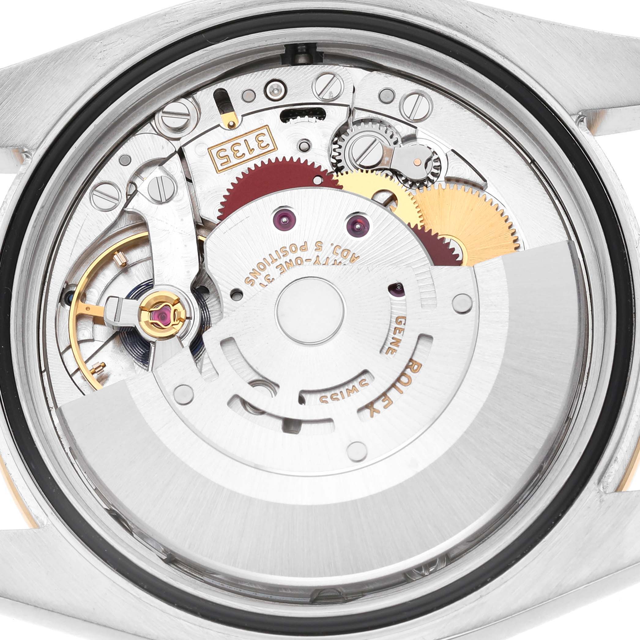 The image shows the internal mechanism of a Rolex Datejust 116243 Men's Stainless Steel Silver Dial watch from the back, highlighting gears and rotor components.