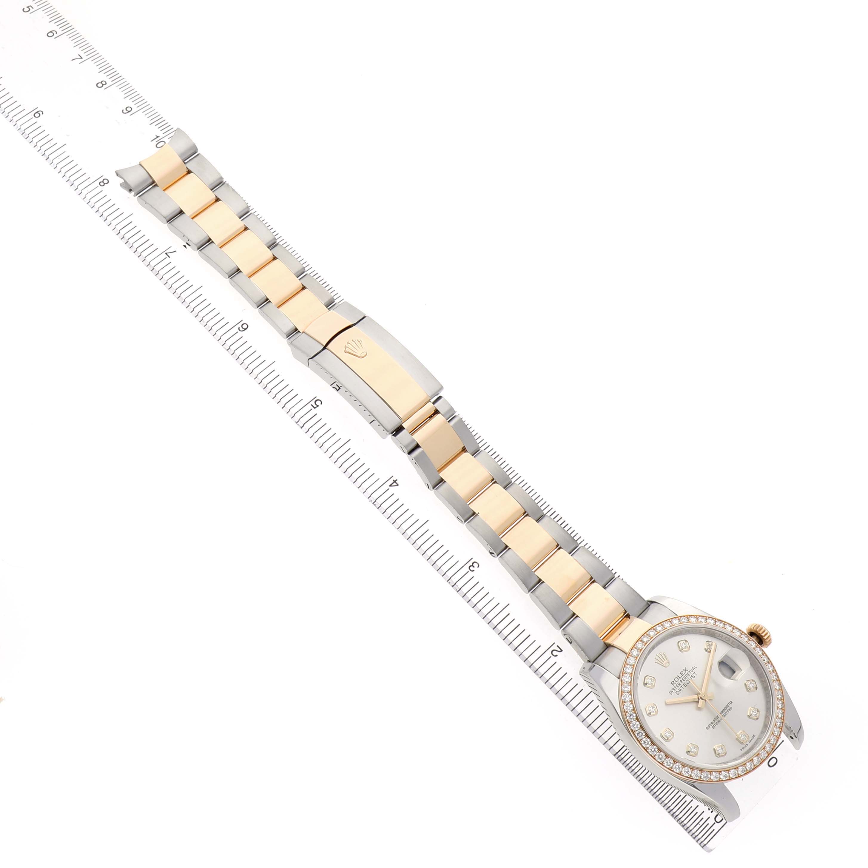 The Rolex Datejust 116243 Men's Stainless Steel Silver Dial watch is shown from above, highlighting its gold and silver bracelet, clasp, and detailed watch face.