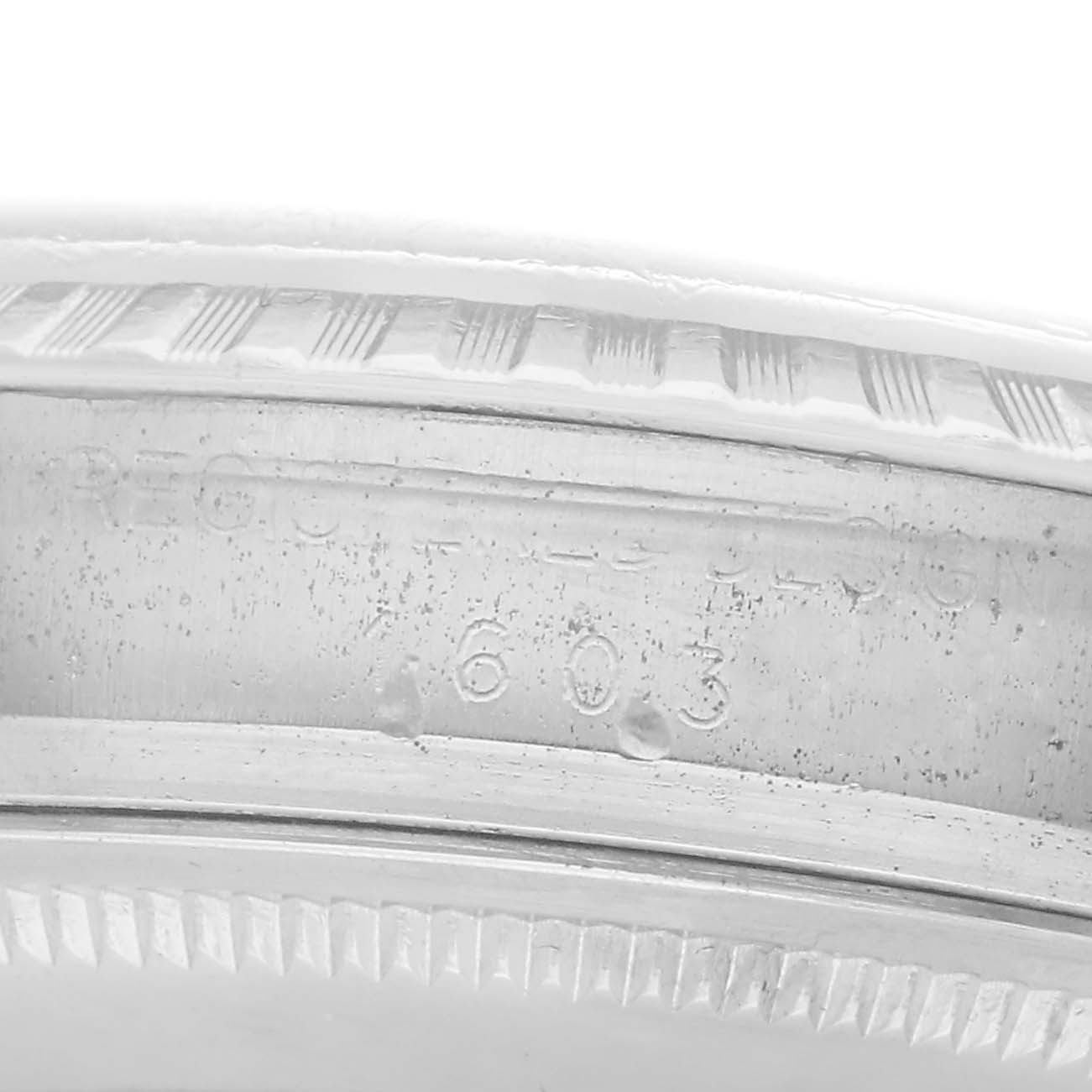The image shows an angled close-up of the edge and engraving on the bezel of a Rolex Vintage Collection Men's watch, model number 1603.