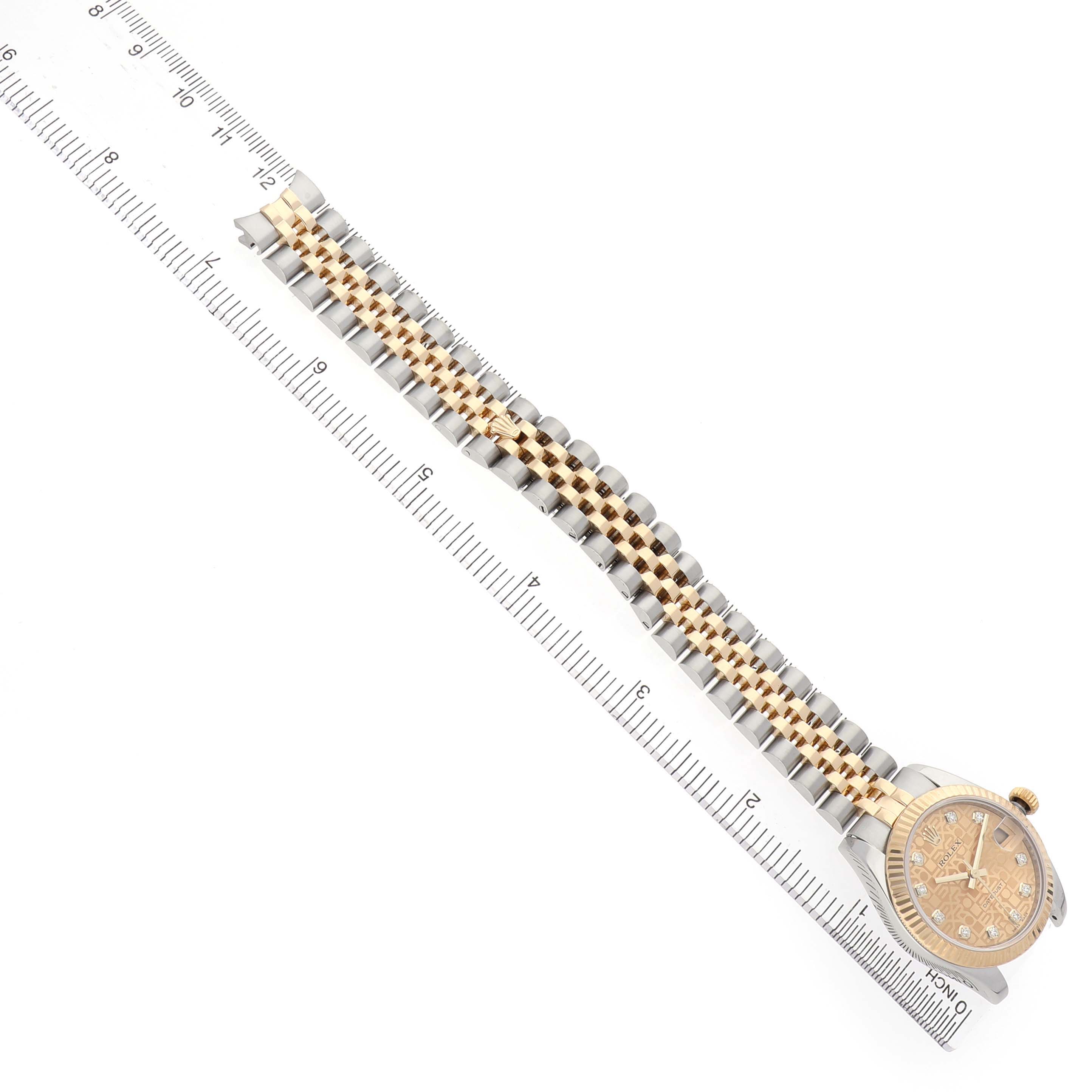 The Rolex Mid-Size 178273 Women's Steel and Gold (two tone) Champagne Dial watch is shown from a top angle, displaying the full band, face, and ruler for scale.