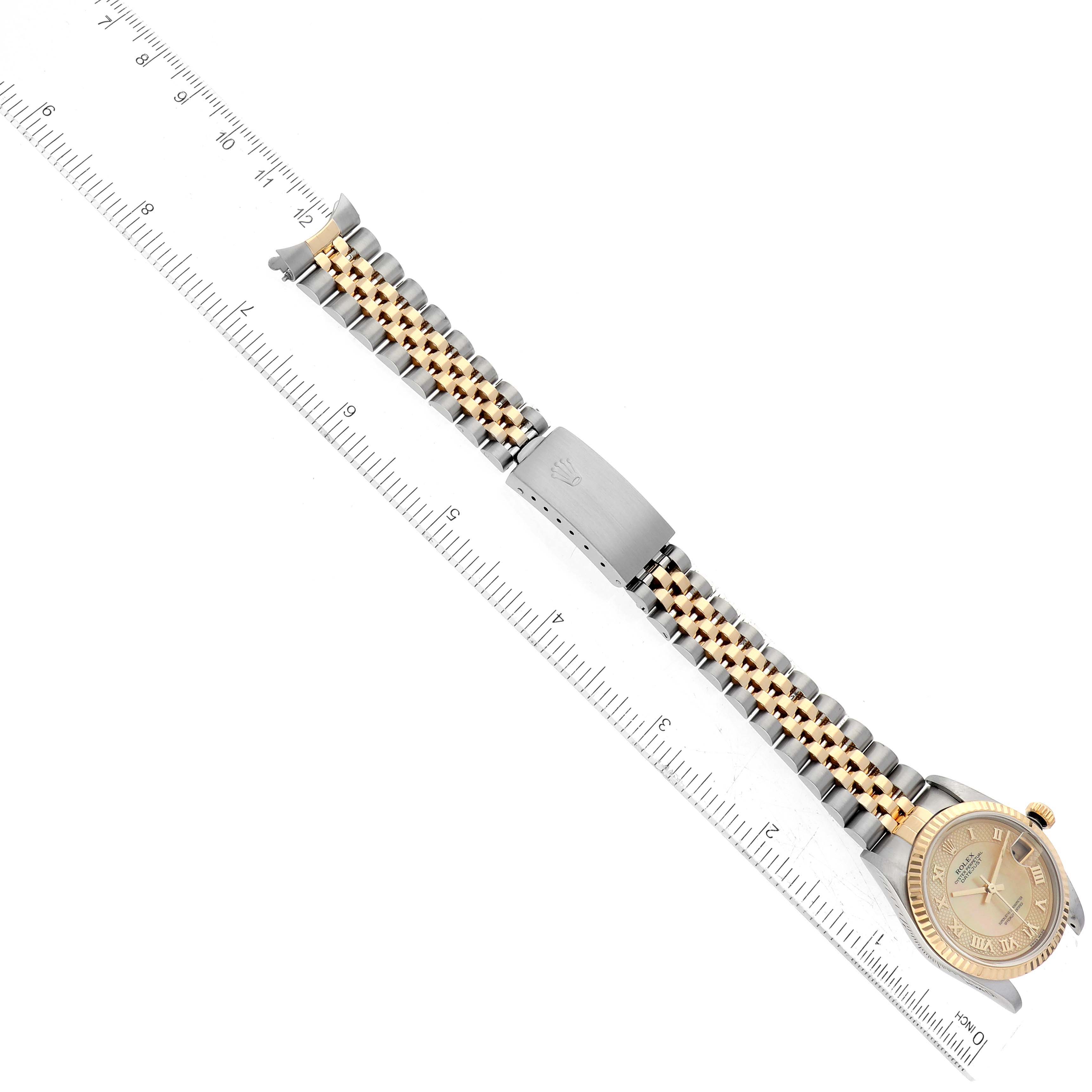 The image shows a top-down view of a Rolex Mid-Size 78273 Women's Steel and Gold (two tone) Mother of Pearl Dial 78273 Women's Steel and Gold (two tone) Mother of Pearl Dial model watch with its bezel, dial, bracelet, and clasp, alongside a ruler.