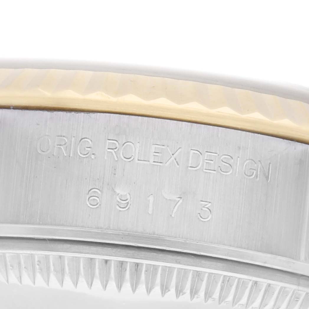 The image shows a close-up of the side of the case of a Rolex Datejust model 69173, highlighting the engraving and bezel details.
