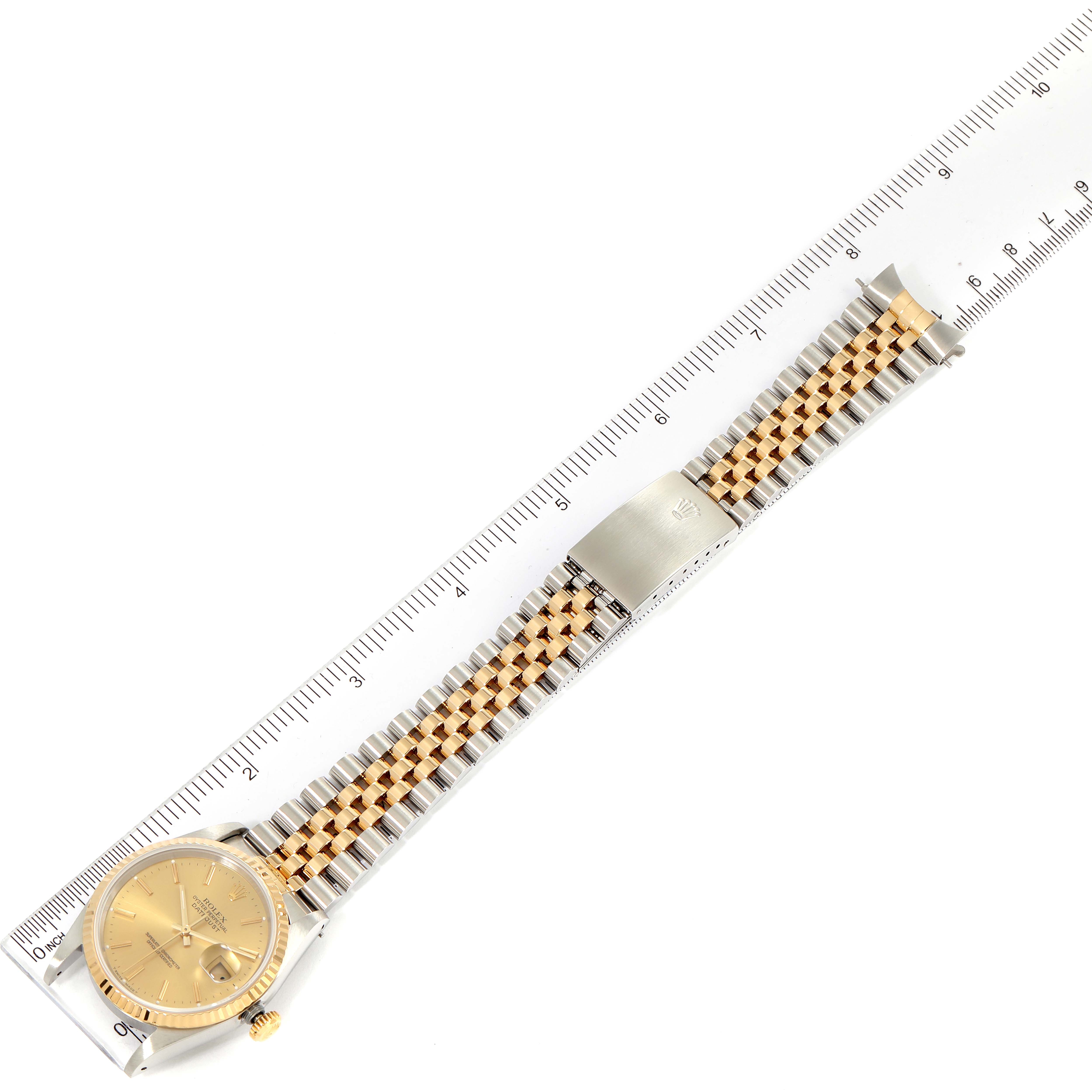 The image shows a Rolex Datejust 16233 Men's Steel and Gold (two tone) Champagne Dial 16233 Men's Steel and Gold (two tone) Champagne Dial watch laid flat, highlighting its dial, jubilee bracelet, and clasp, alongside a ruler for scale.