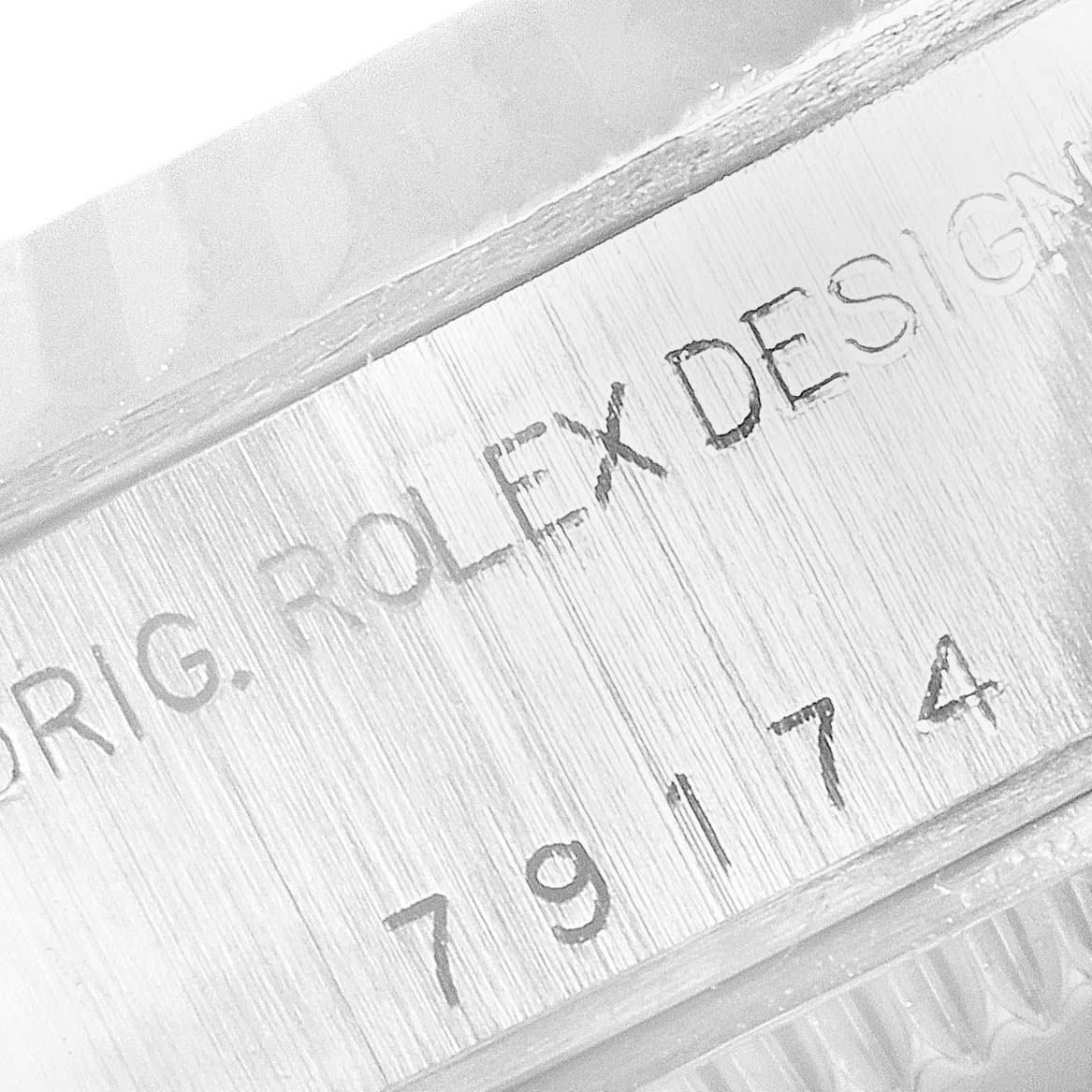 This close-up image shows the engraved serial number and "ROLEX DESIGN" on the side of a Rolex Datejust 79174 Women
s Stainless Steel Black Dial 79174 Women
s Stainless Steel Black Dial watch case.