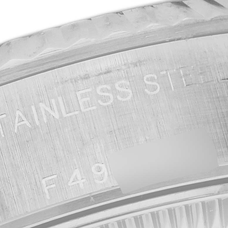 The image shows a close-up of the side of a Rolex Datejust 79174 Women's Stainless Steel White Dial 79174 Women's Stainless Steel White Dial watch, highlighting engravings on the stainless steel bezel.