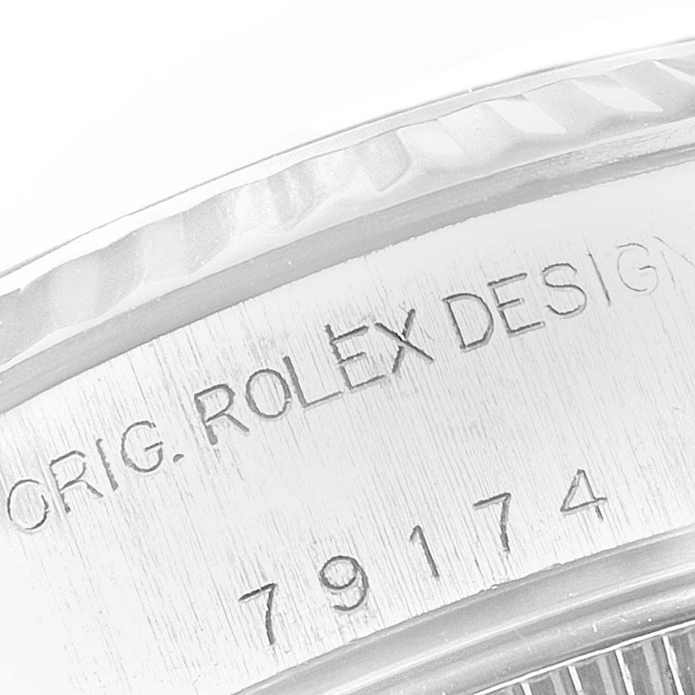 This is a close-up of the side of a Rolex Datejust 79174 Women
s Stainless Steel Silver Dial 79174 Women
s Stainless Steel Silver Dial watch, showing engraved text including the serial number.