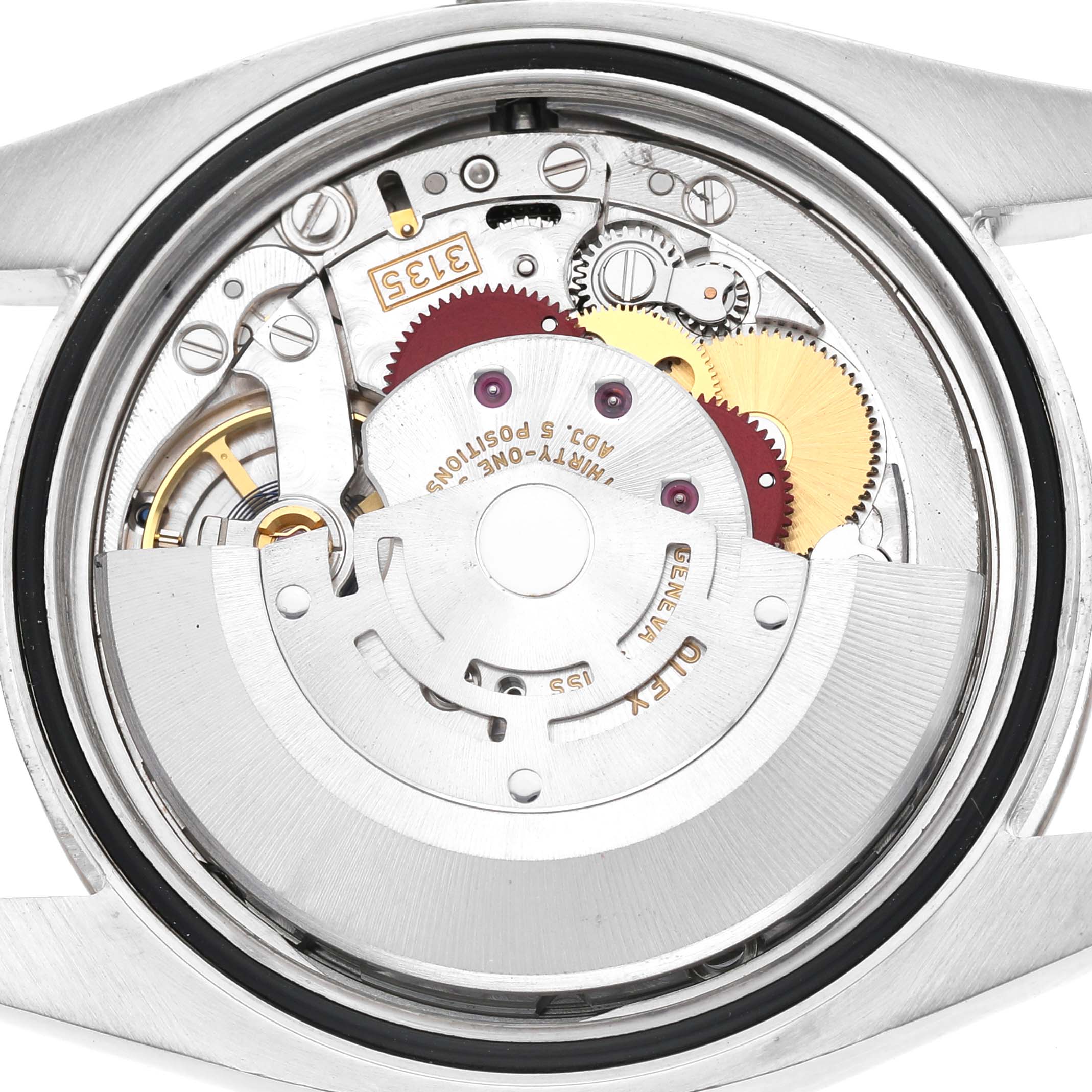 The image shows a close-up of the movement of a Rolex Datejust 116234 Men's Stainless Steel Silver Dial, highlighting gears and mechanical components.