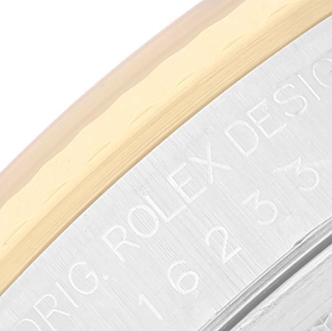 This image shows a close-up of the bezel and engraved details on a Rolex Datejust 16233 Men's Steel and Gold (two tone) Black Dial 16233 Men's Steel and Gold (two tone) Black Dial watch.