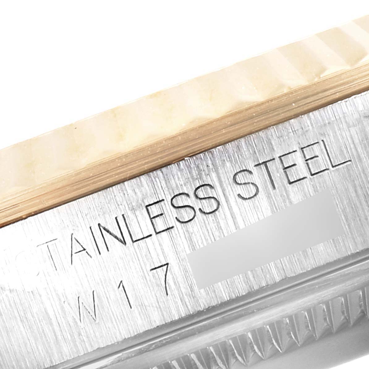 The image shows an angled close-up of a stainless steel part of the Rolex Datejust 16233 Men's Steel and Gold (two tone) Champagne Dial 16233 Men's Steel and Gold (two tone) Champagne Dial model watch case with visible engraving.