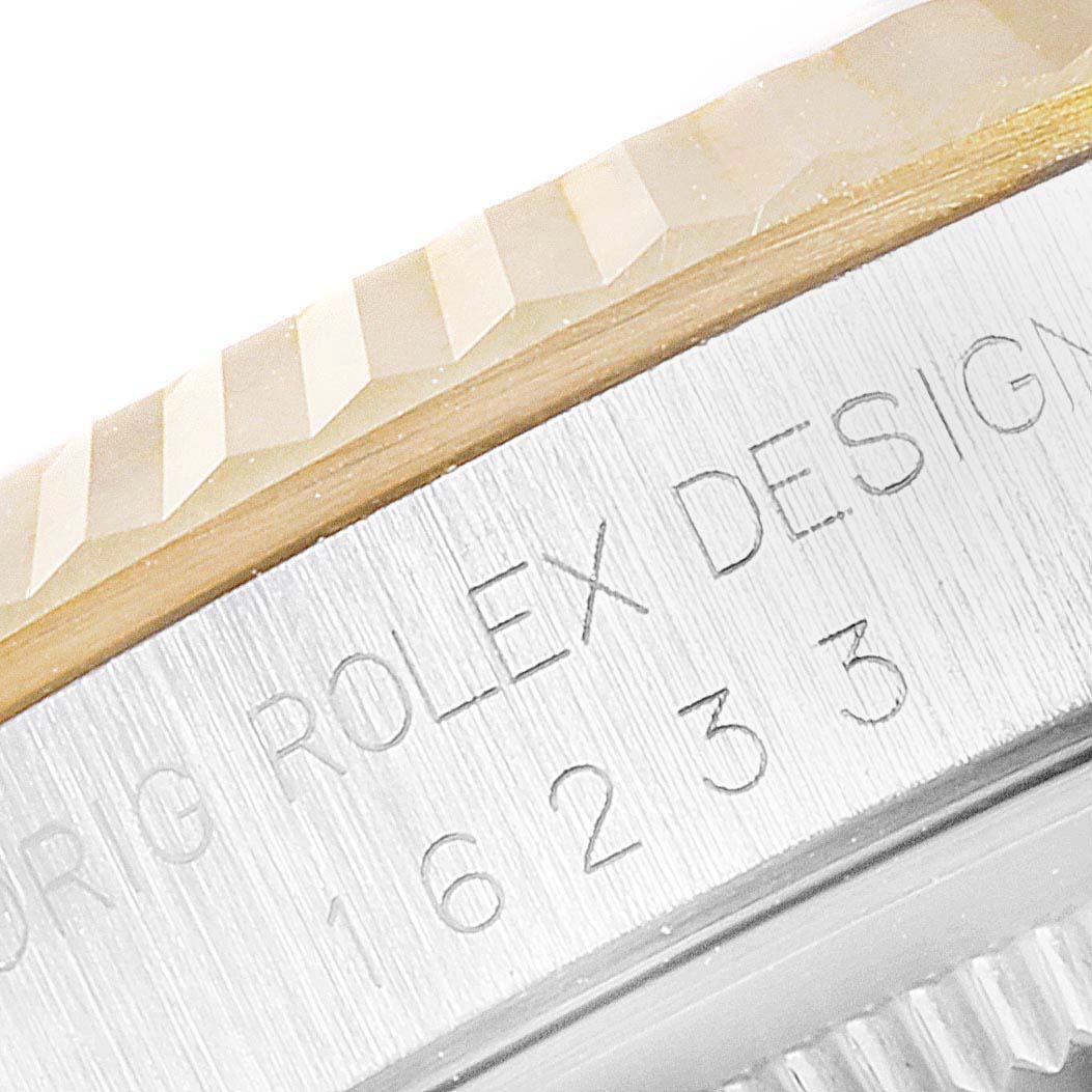 This close-up image shows a portion of the bezel and engraved serial number of a Rolex Datejust 16233 Men's Steel and Gold (two tone) Champagne Dial 16233 Men's Steel and Gold (two tone) Champagne Dial model.
