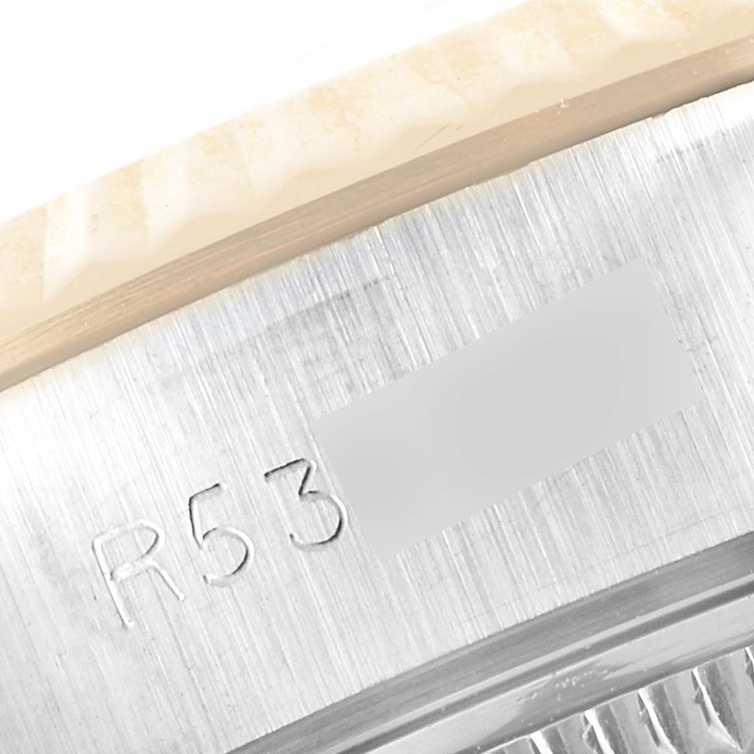 The image shows a close-up of the serial number engraving on the caseback edge and bezel of a Rolex Datejust 69173 Women
s Steel and Gold (two tone) Champagne Dial 69173 Women
s Steel and Gold (two tone) Champagne Dial watch.