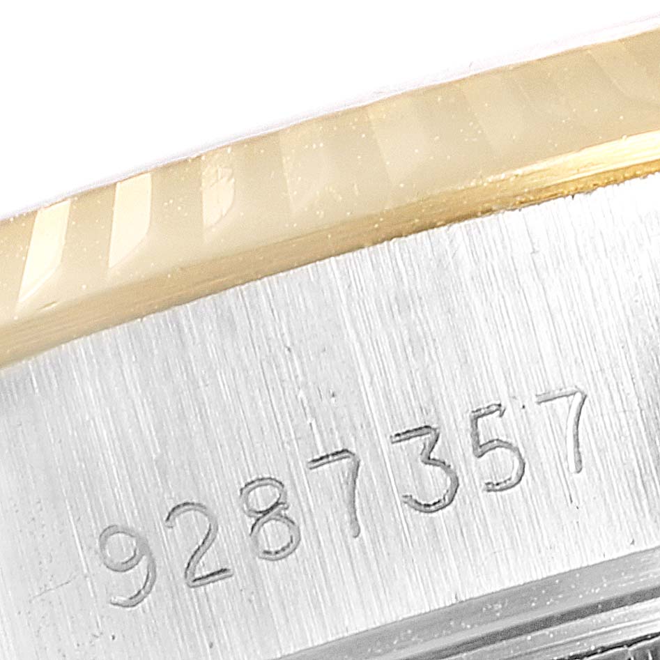 The image shows a close-up of the serial number engraved on the brushed metal case of a Rolex Datejust 69173 Women
s Steel and Gold (two tone) Champagne Dial 69173 Women
s Steel and Gold (two tone) Champagne Dial watch, including part of the fluted bezel.