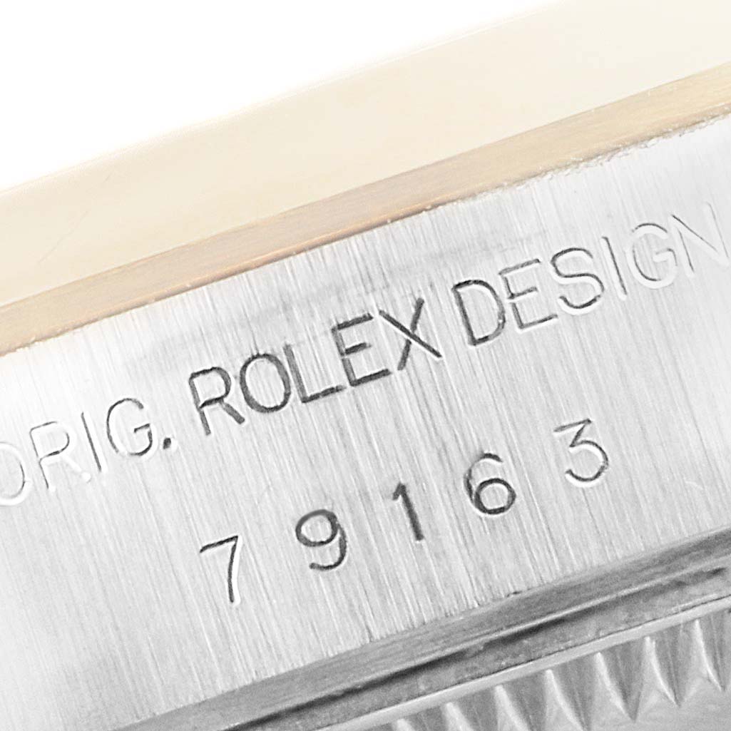 The image shows a close-up of the engraved serial number and branding on the side of a Rolex Datejust 79163 Women
s Steel and Gold (two tone) Mother of Pearl Dial 79163 Women
s Steel and Gold (two tone) Mother of Pearl Dial watch case.