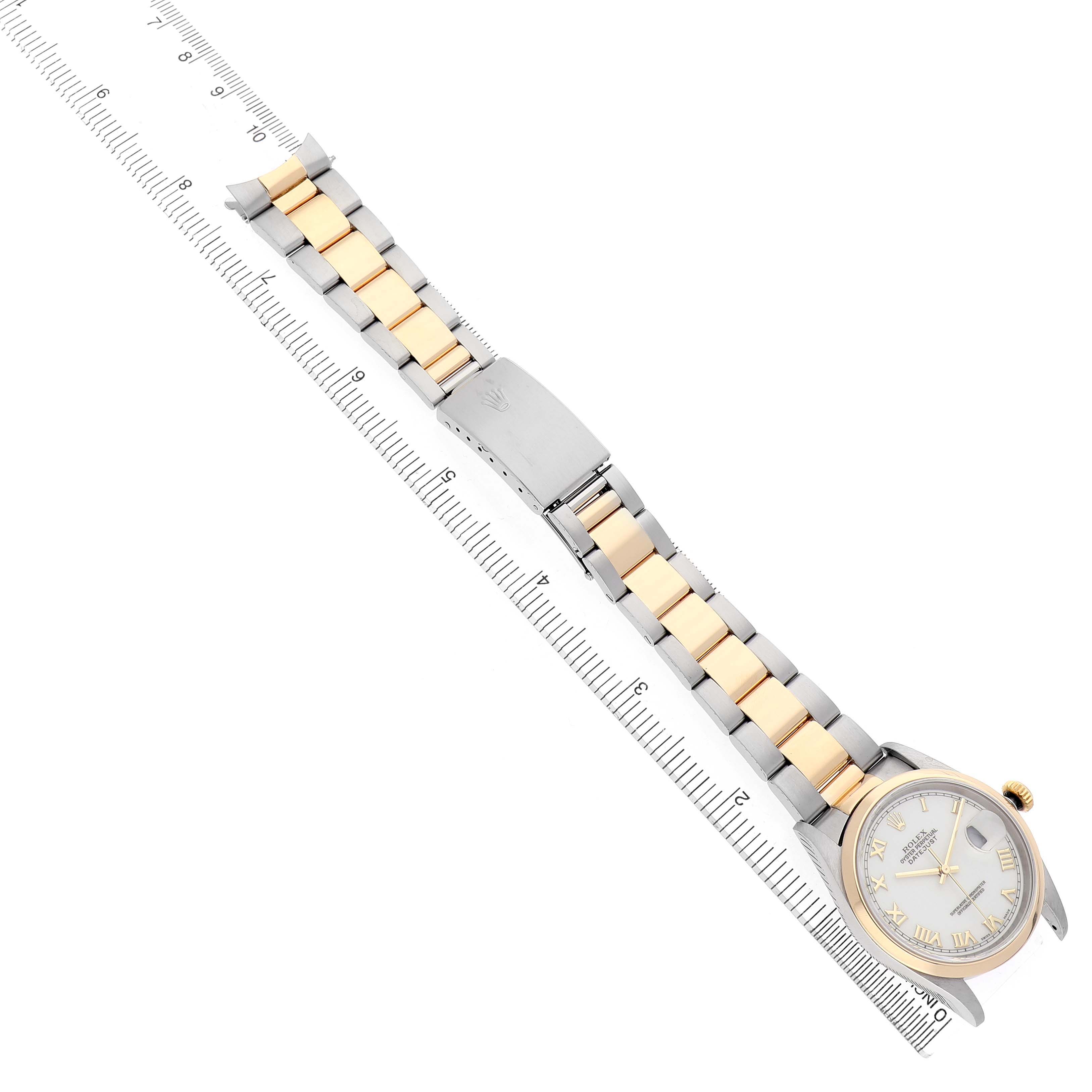 The Rolex Datejust 16203 Men's Stainless Steel White Dial watch is shown from a top-down angle, displaying the two-tone bracelet and face on a ruler.