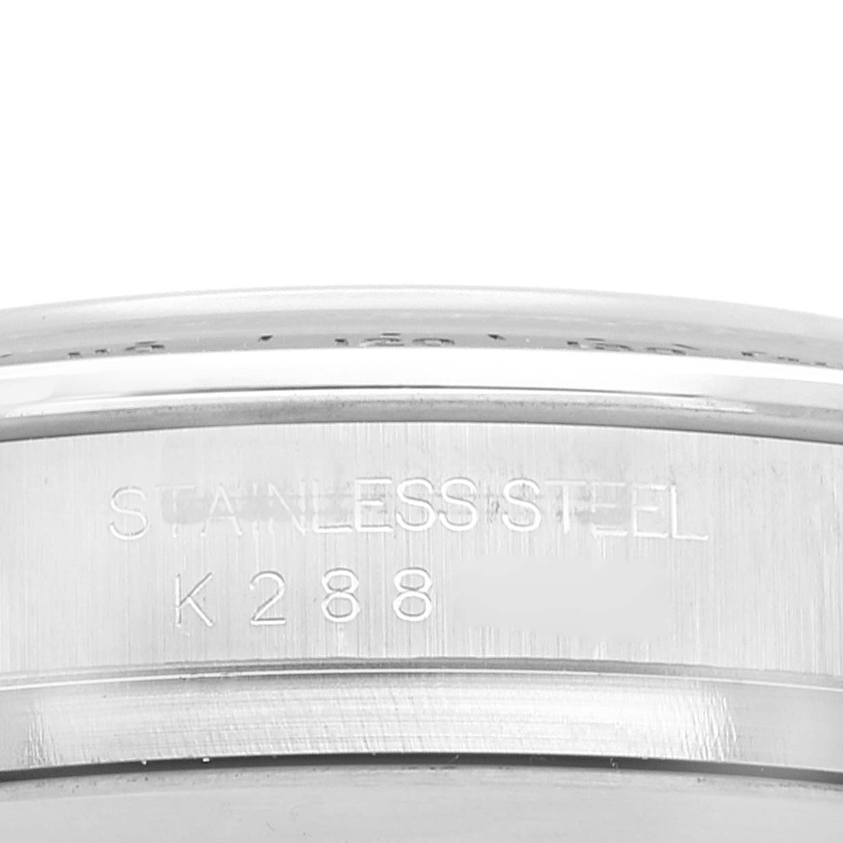 The image shows a close-up of the side engraving on a Rolex Daytona 116520 Men's Stainless Steel Black Dial 116520 Men's Stainless Steel Black Dial model, highlighting the "Stainless Steel" stamp and some serial numbers.